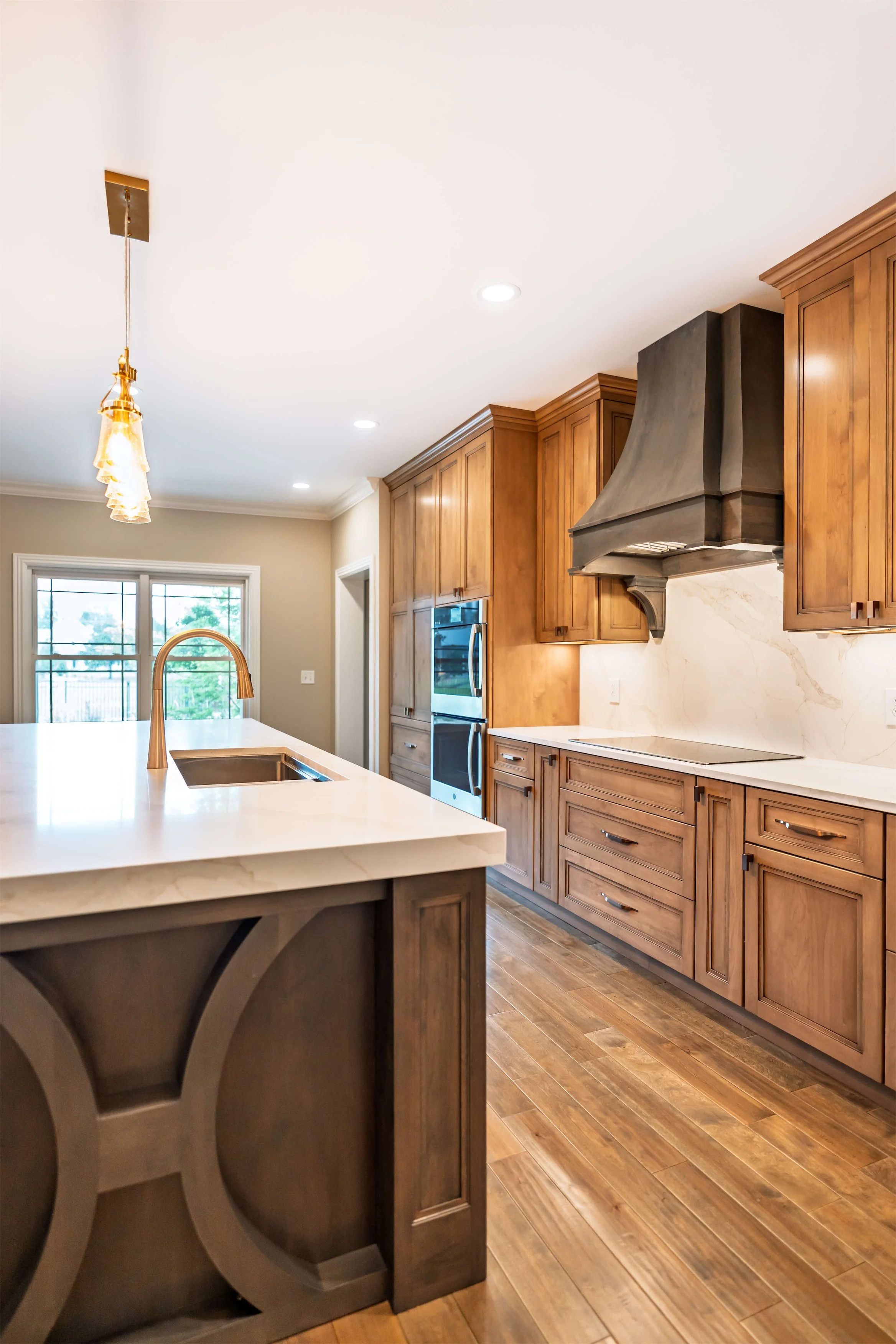 A Nashville, TN kitchen with a large island and stained cabinets and custom hood.
