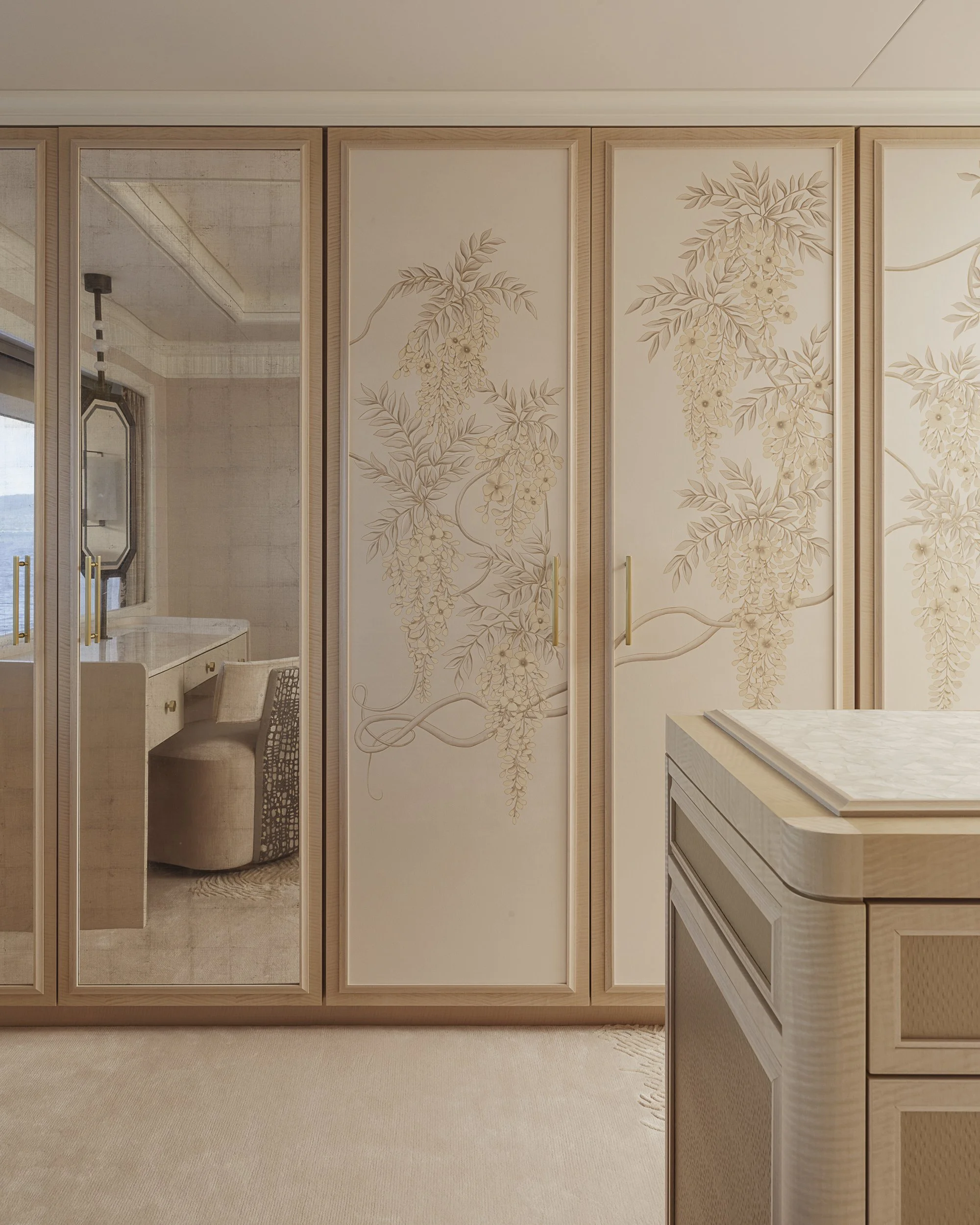 Closet with decorative floral panels, mirrored door, dressing table, and beige carpet.