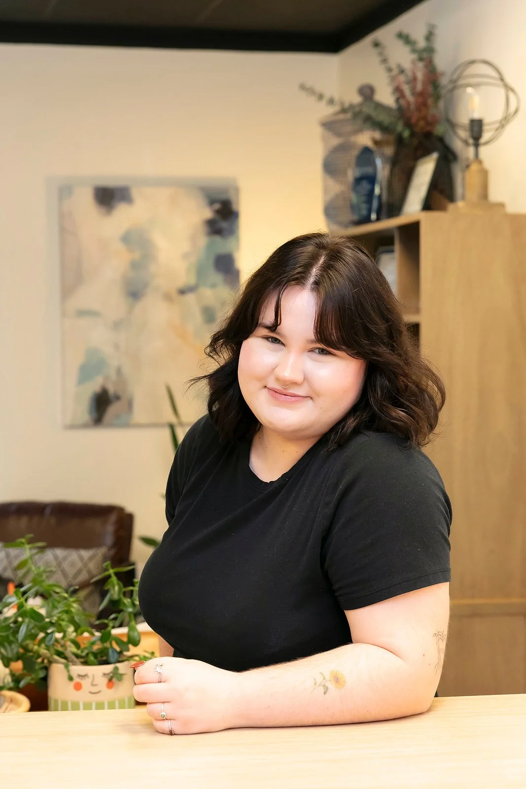 Keegan Norman leaning on a table and smiling. Black shirt. 