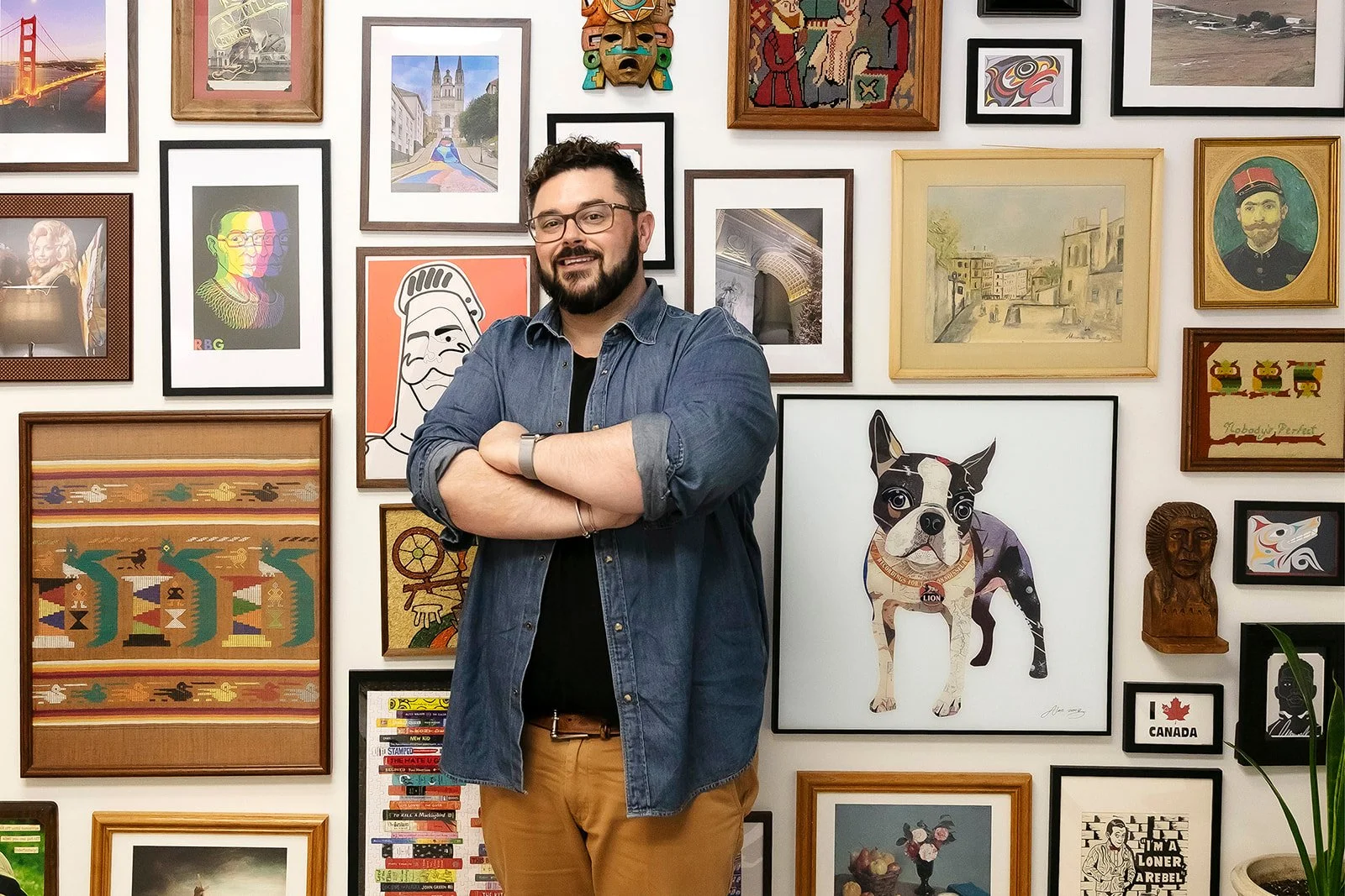 Hutch leaning with arms crossed on wall of pictures