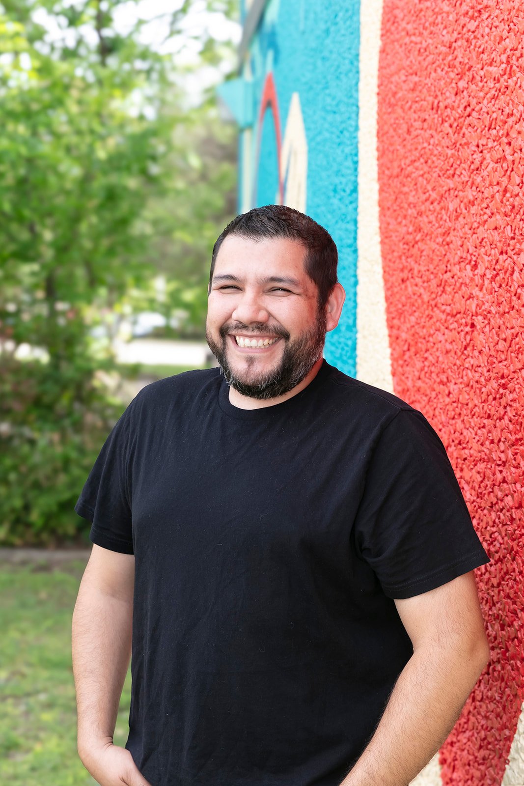 Javi Adame smiling against a mural