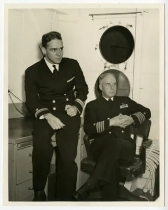 Captain Robert W. Hayler and his older son Robert W. Hayler, Jr., in captain's cabin of U.S.S. Honolulu.&nbsp;&nbsp;&nbsp;