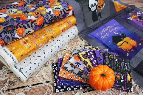 Halloween-themed gift bags, wrapping paper with pumpkins, skulls, and ghosts, and a small pumpkin decoration.