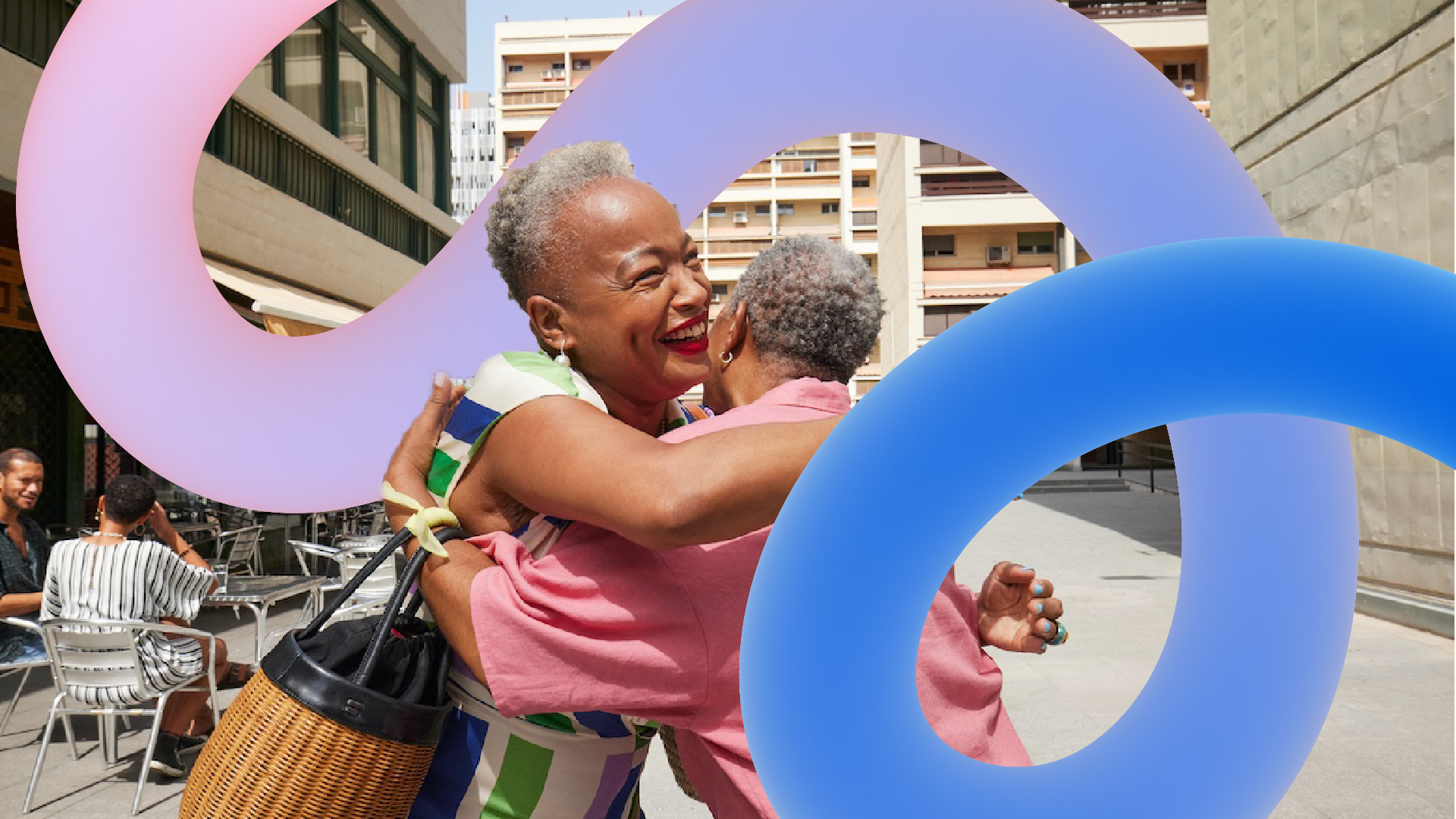 Two elderly women with gray hair hug and smile happily outdoors in an urban setting, with colorful abstract shapes overlaying the image.