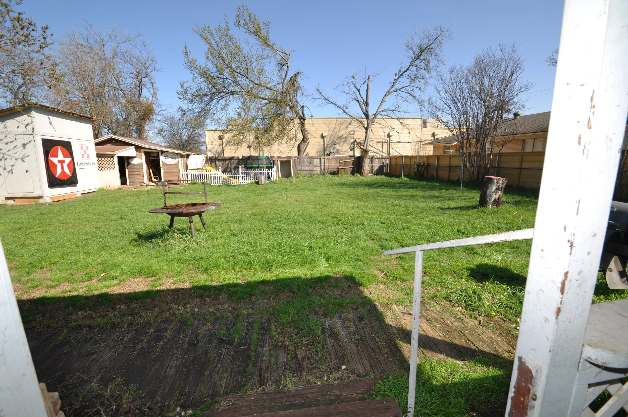 Back yard from porch with storage sheds and privacy