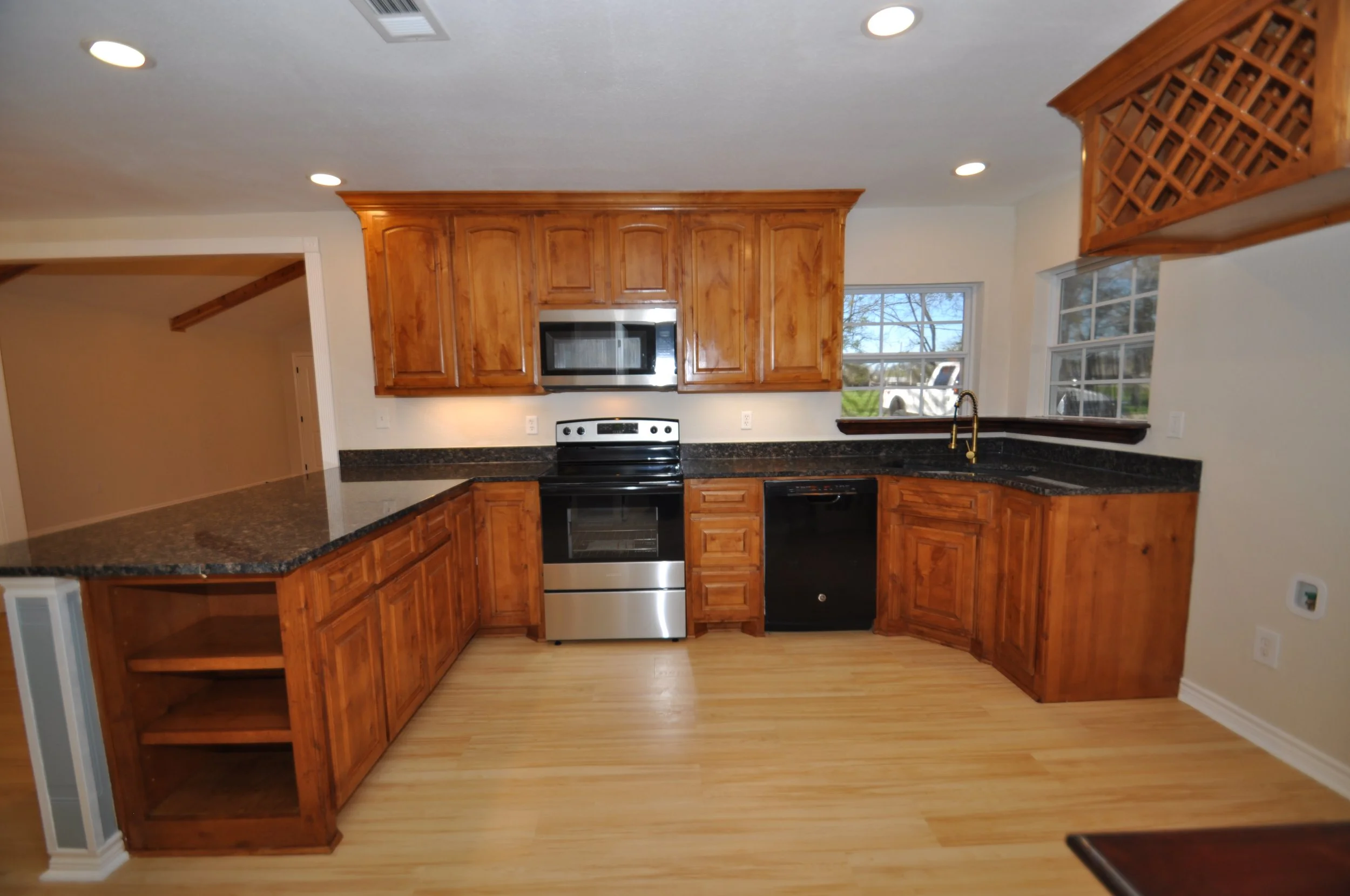 Kitchen with new range and microwave vent hood. Solid wood and many upscale details...raised panels, shelves with edge profiles, full extension slides on drawers, wine rack above fridge space and much more.