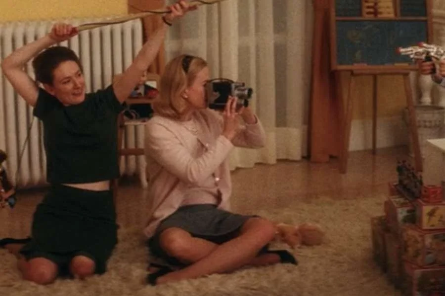 Nicole Kidman as Grace Kelly wearing a pink cardigan sweater set and gray skirt