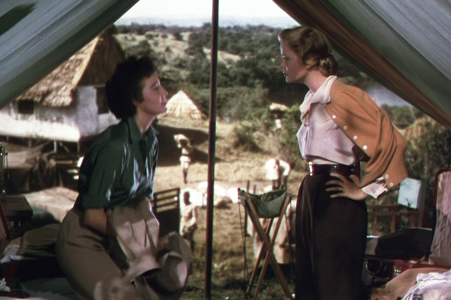 Grace Kelly wearing a white blouse tucked into brown pants in Mogambo opposite Ava Gardner.