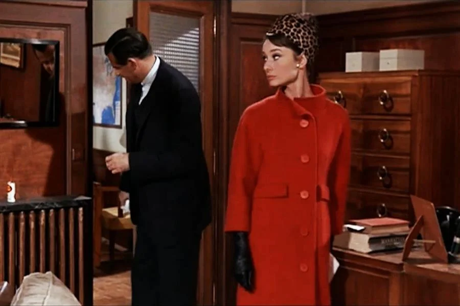 Audrey Hepburn wearing a red wool coat in Charade
