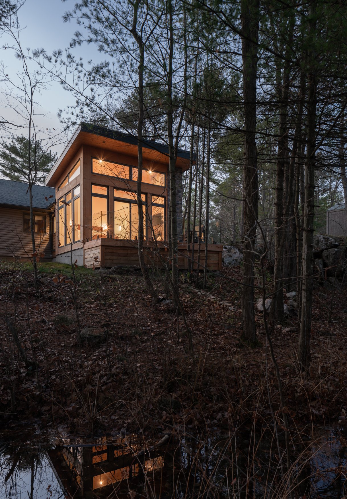 Timber clad modern addition at dusk in the Muskoka wilderness
