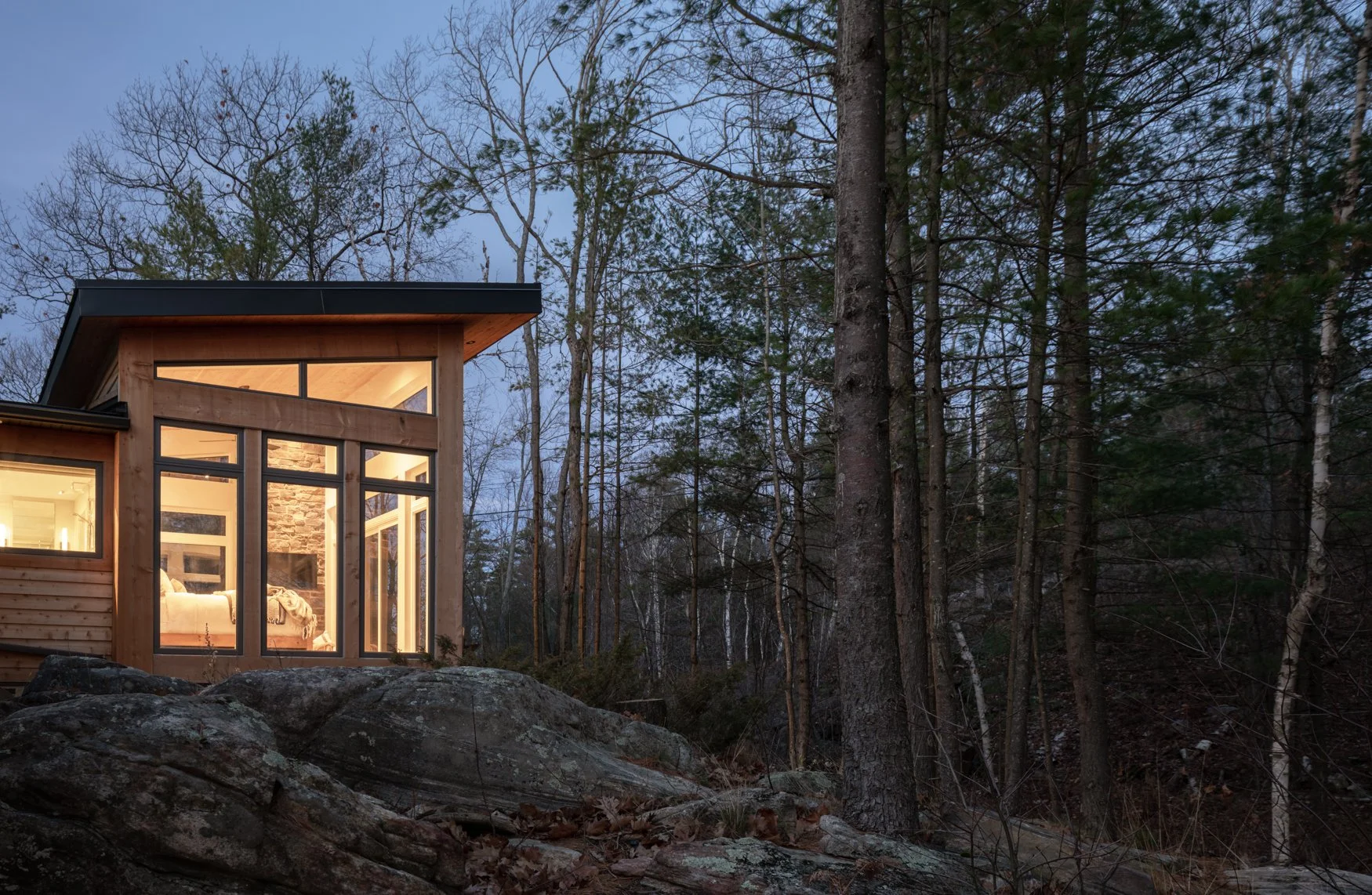 Timber clad modern addition at dusk in the Muskoka wilderness
