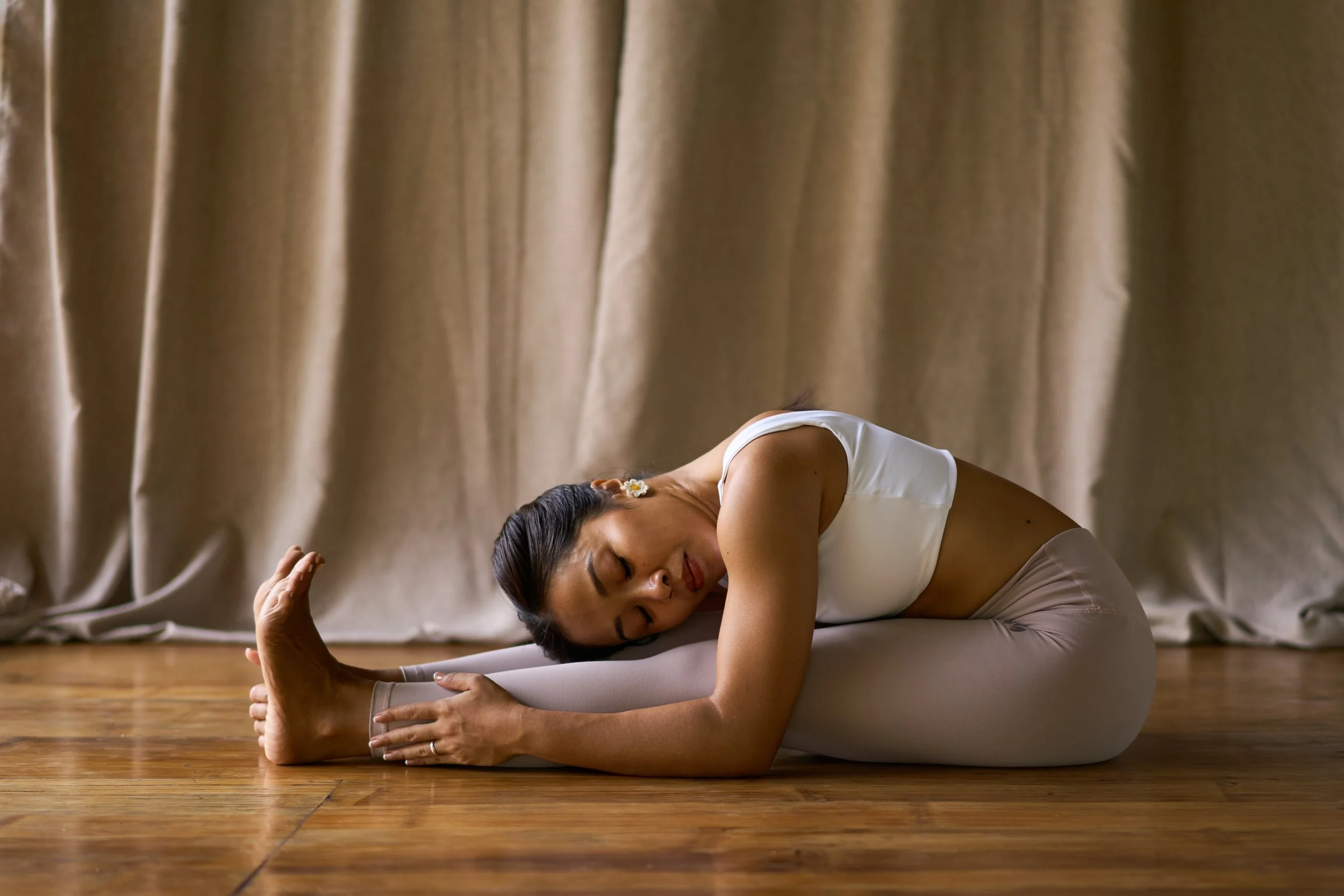 founder of anahaw practicing yoga, in a seated forward fold, embodying a sense of calm and connection to breath, body, and mind