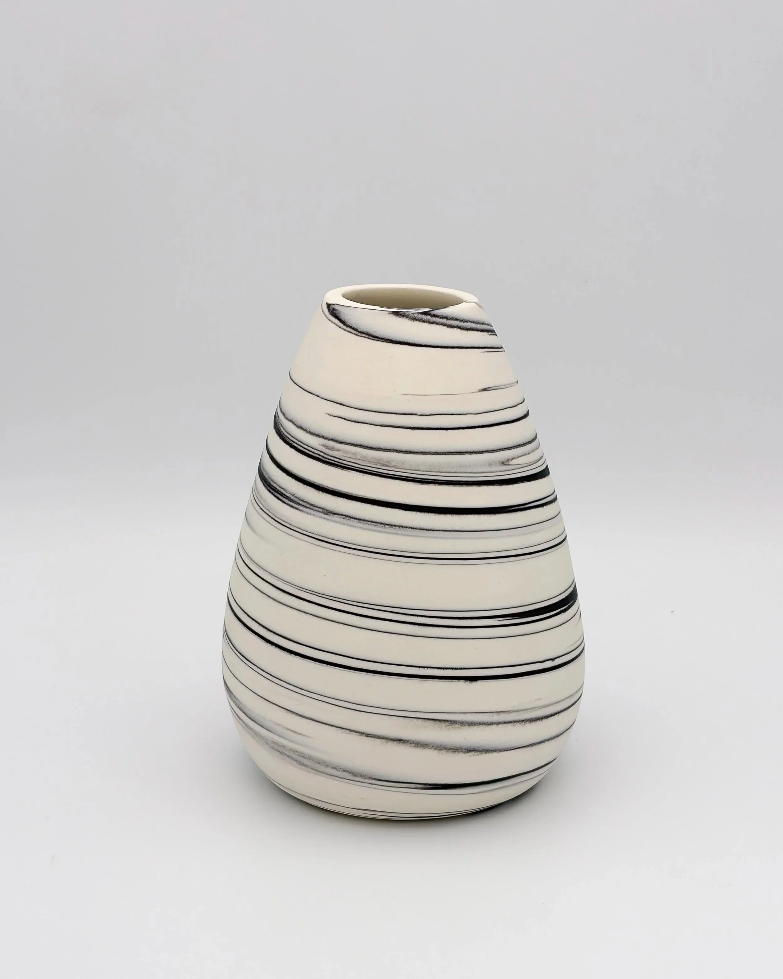 A ceramic vase with a rounded, widened base that tapers toward the top, designed with horizontal black lines on a white background.