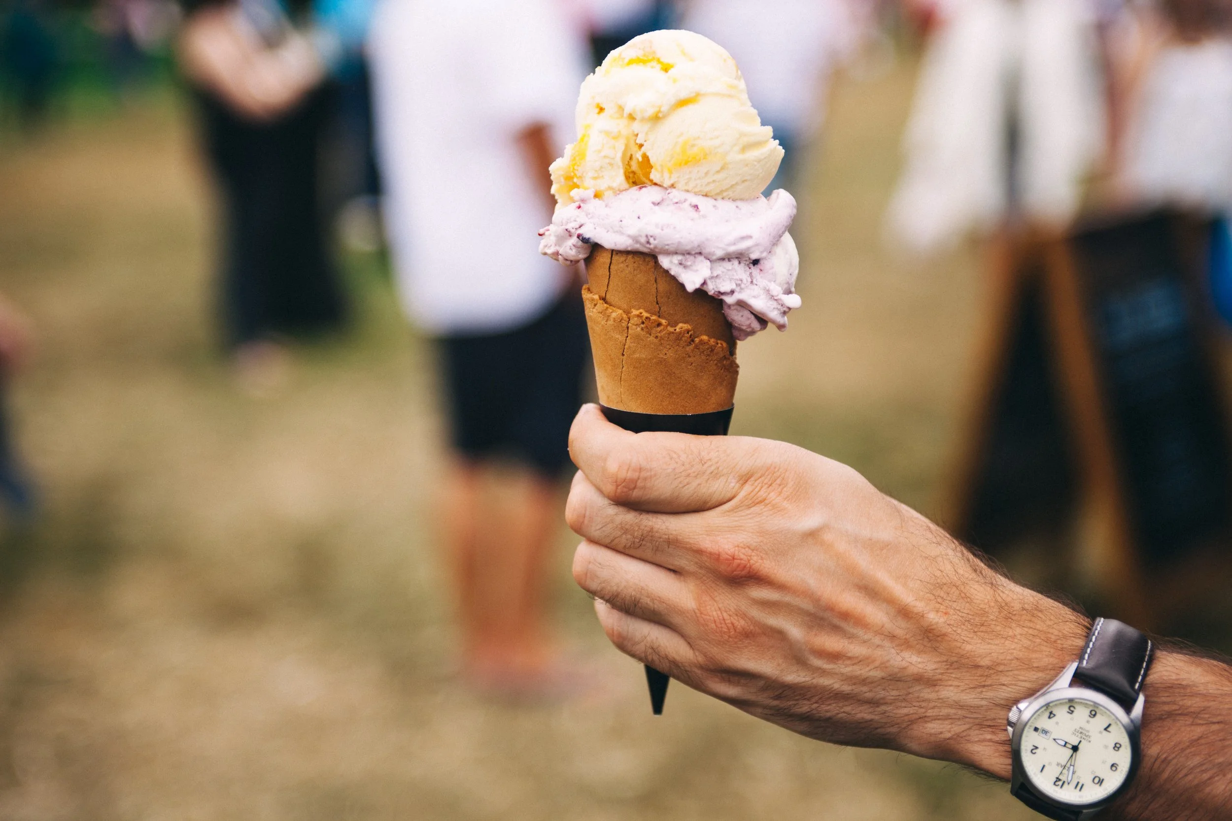 Hand with watch holding ice cream cone
