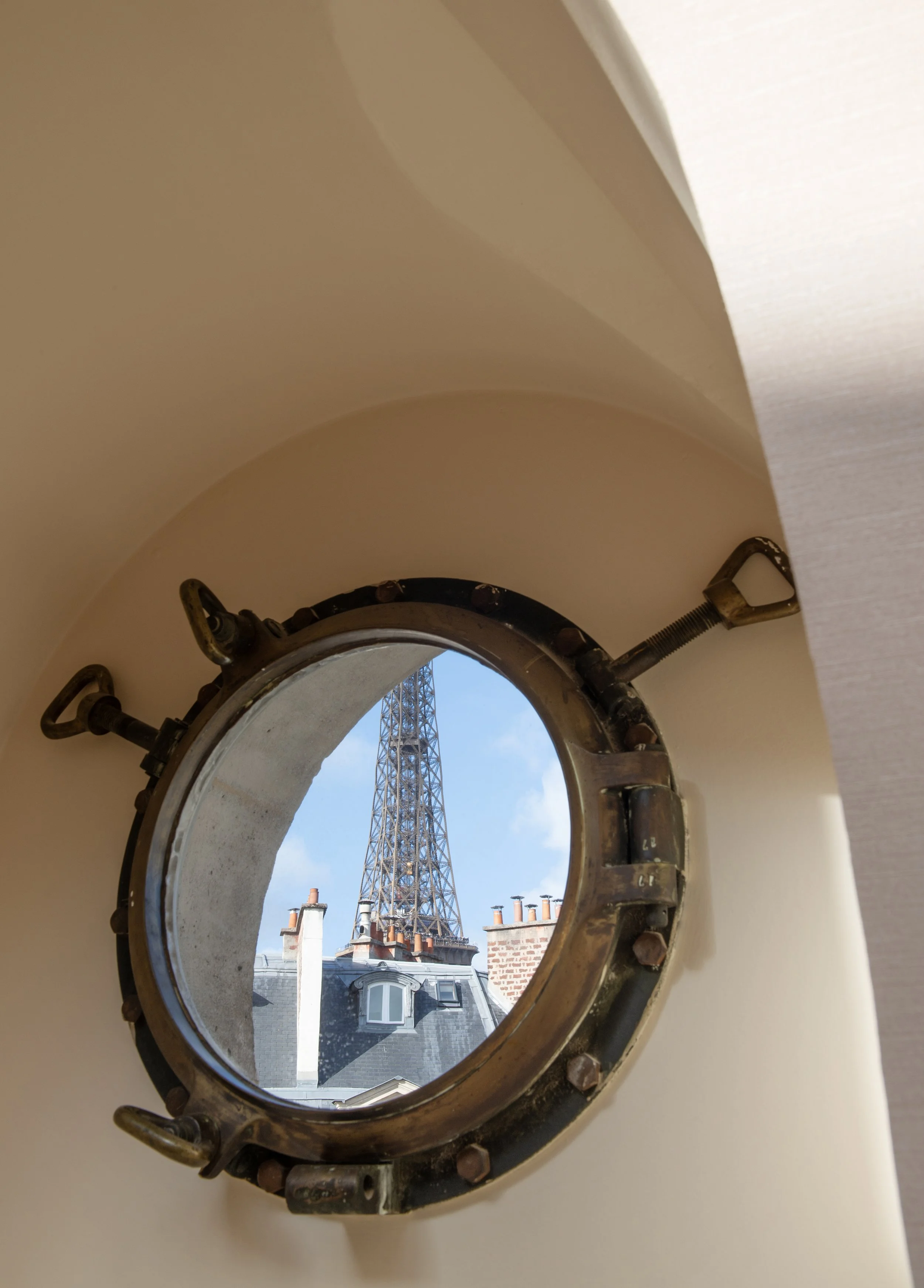 Vue de la tour Eiffel depuis le hublot d'un appartement haussmannien, Paris 7e - Maison Babel, architectes d'intérieur à Paris