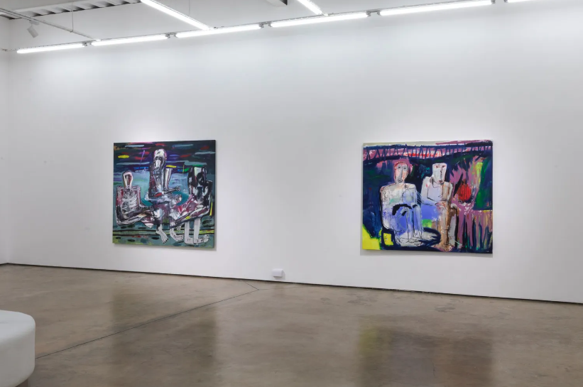 Two colorful abstract paintings hanging on a plain white gallery wall.