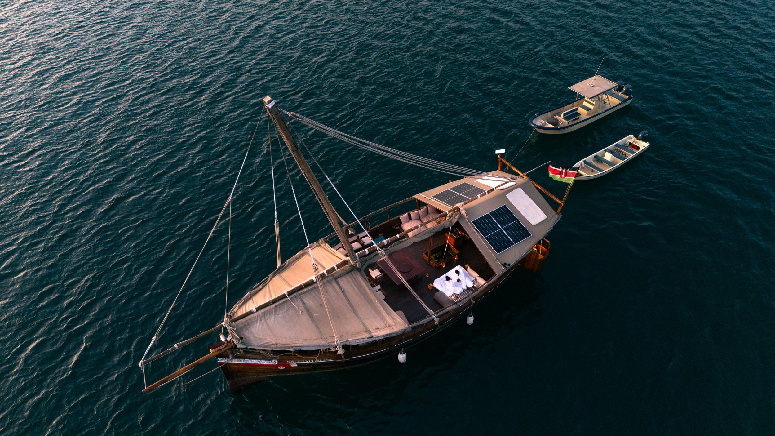 Traditional wooden dhow sailing off Lamu, Kenya, offering an authentic Swahili Coast experience on a North Node Journeys safari through East Africa