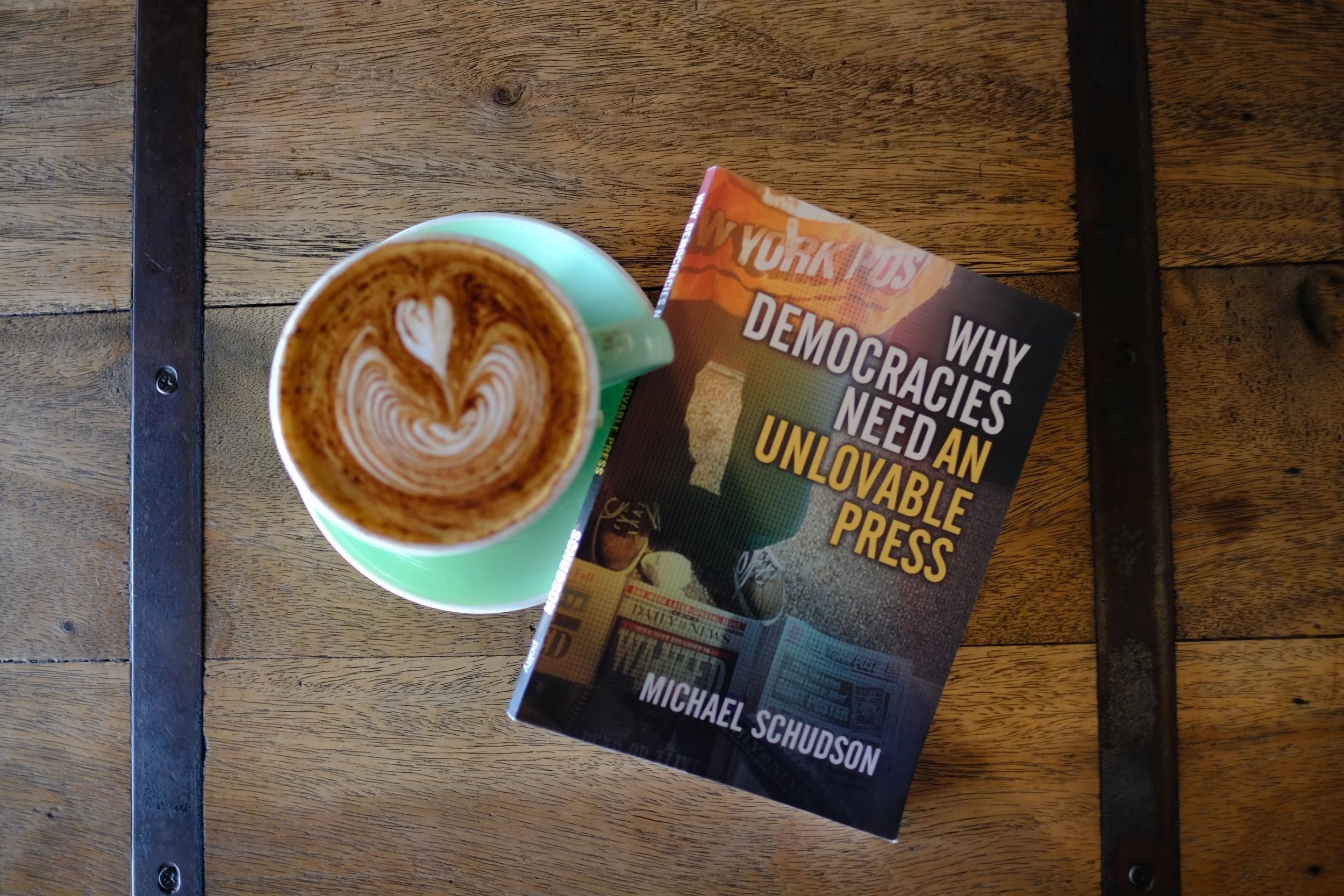 Journalism book and cafe coffee on wood table.