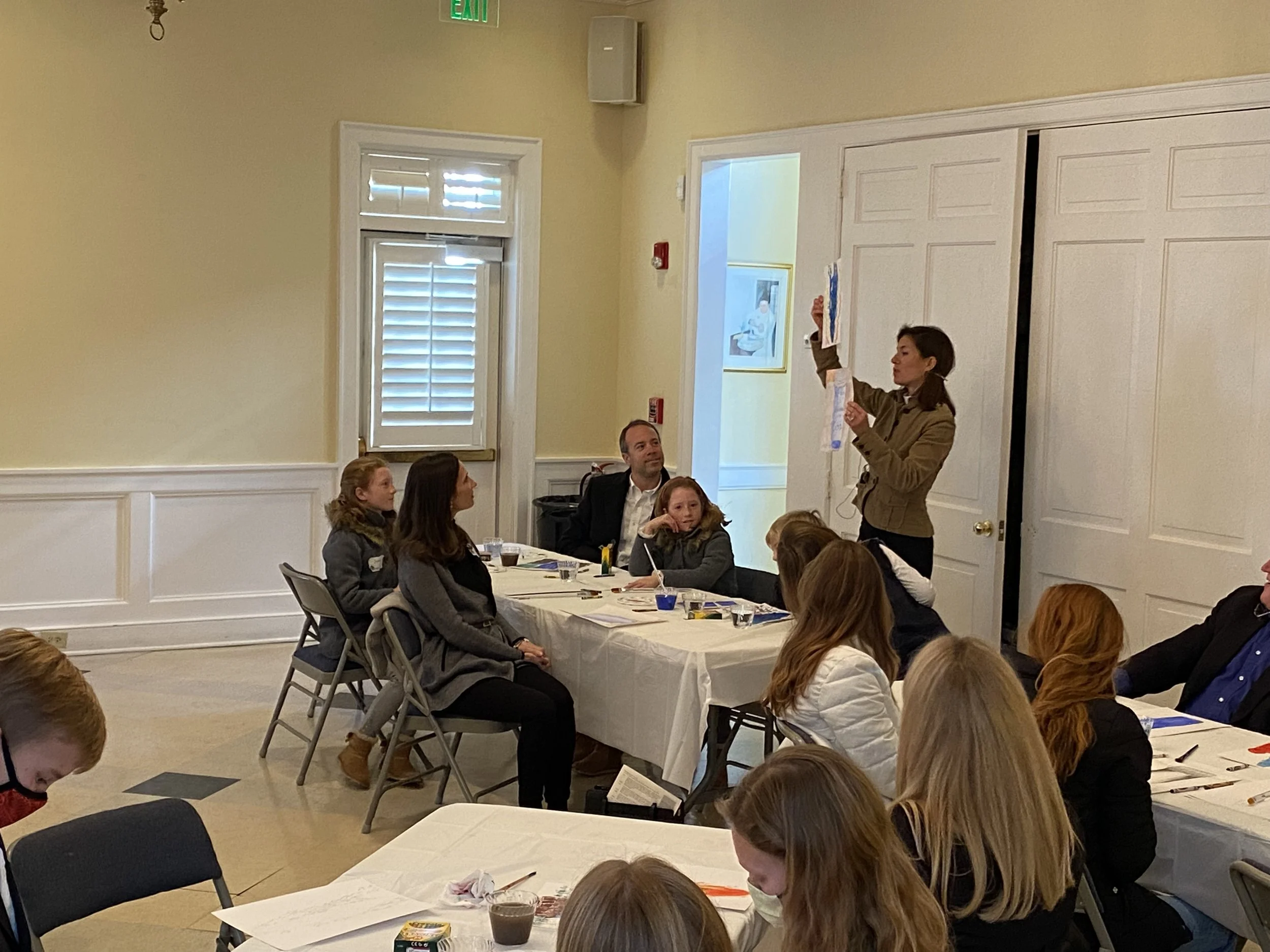 Kate assists the families as they describe their work for the rest of the group.