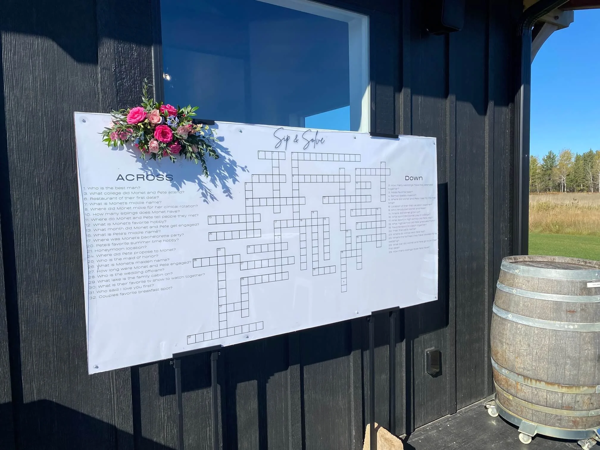 Custom acrylic wedding crossword puzzle decorated with colorful flowers outside Ivy Black in Duluth, Minnesota.