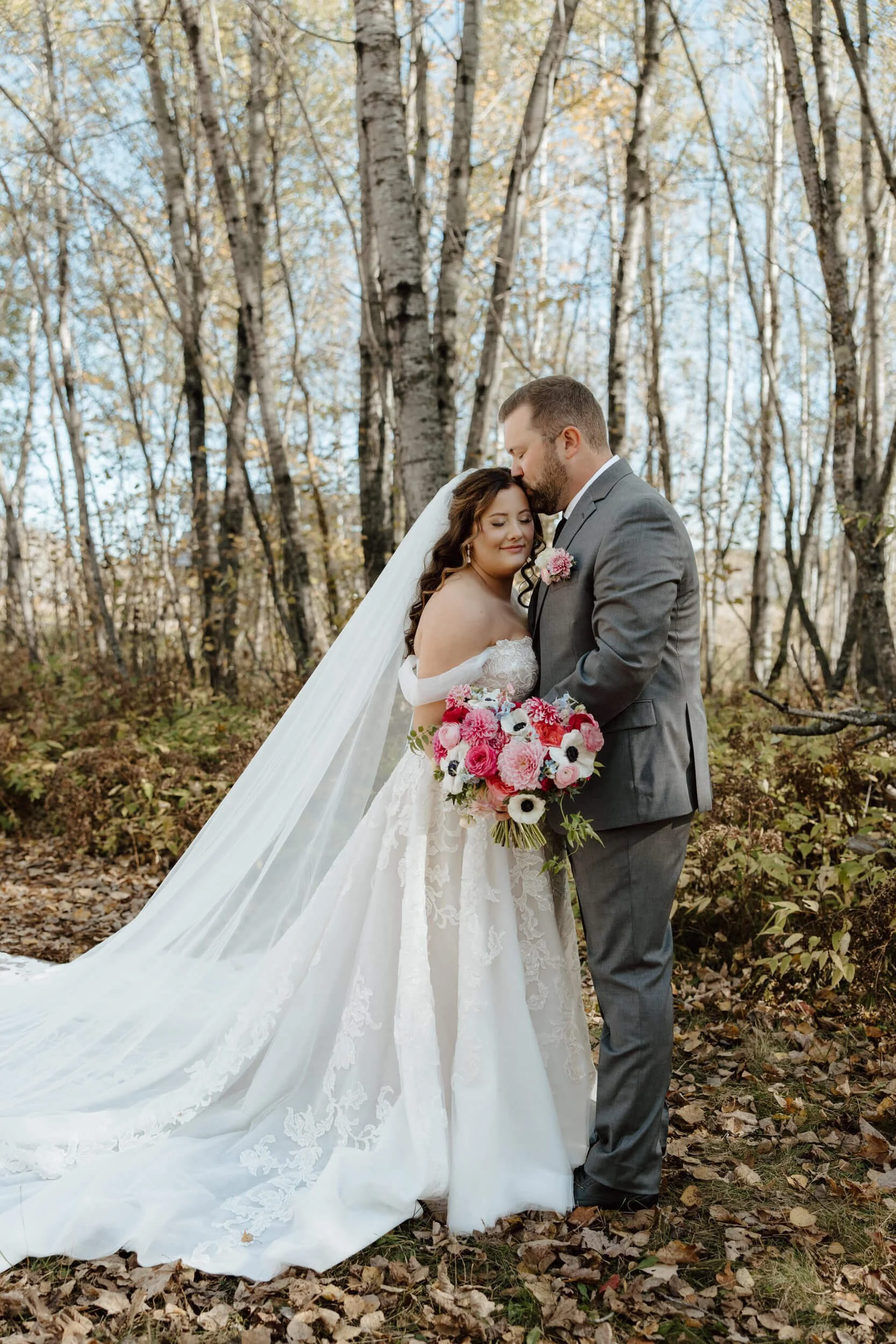 groom-kissing-bride-forehead-fall-wedding-ivy-black.jpg