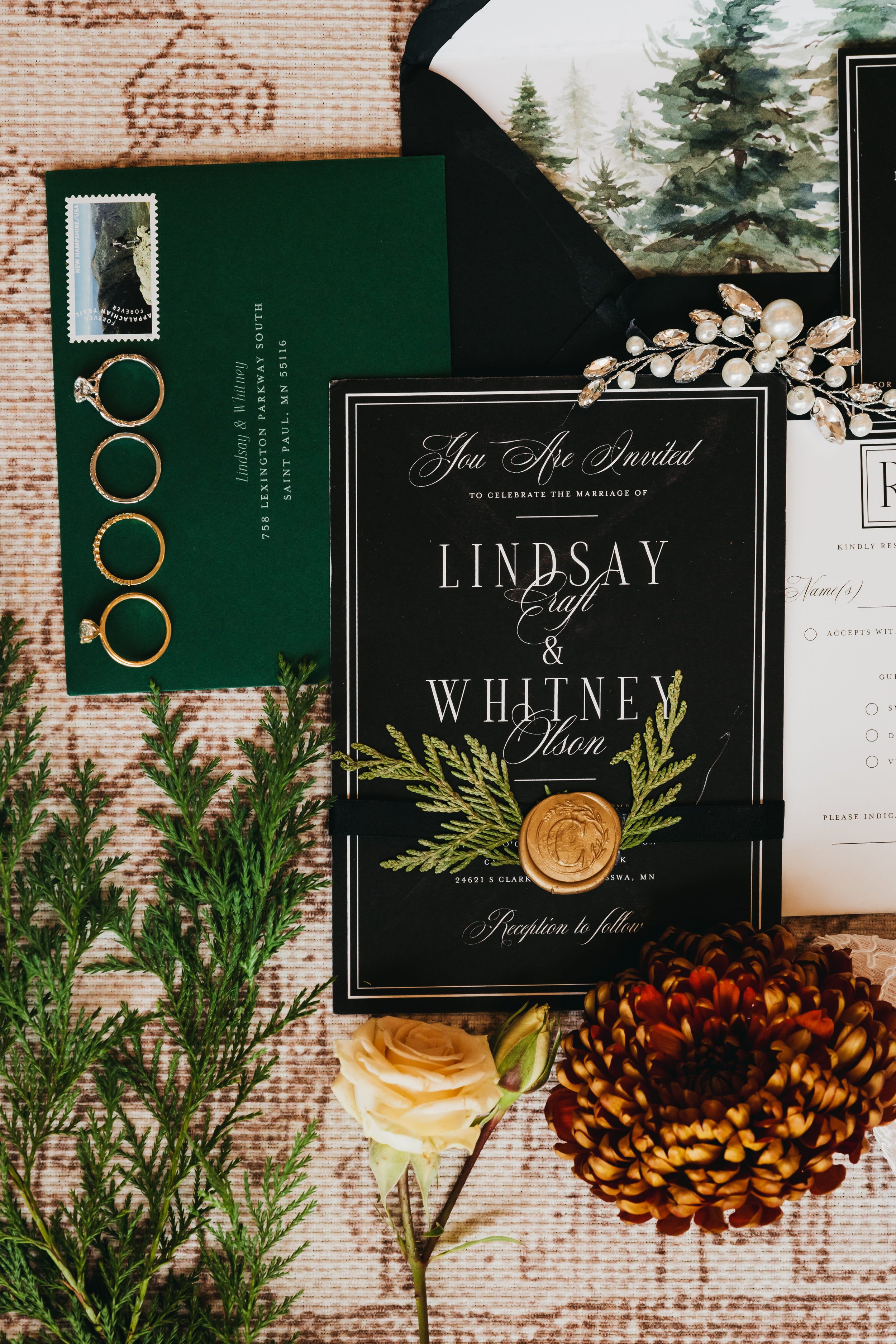 Wedding invitations styled with neutral and evergreen florals for a Nisswa, Minnesota wedding.