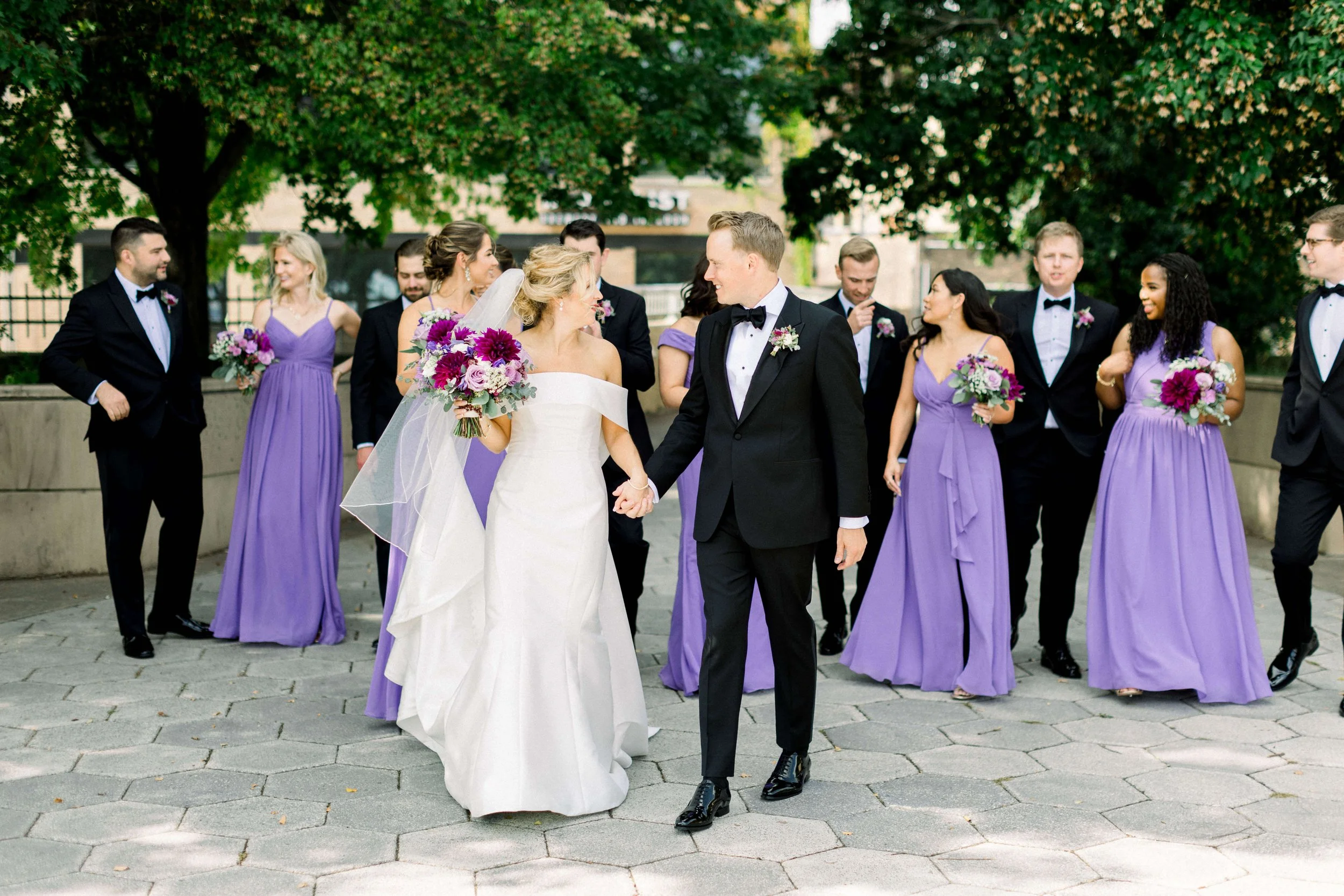 Wedding party at Greysolon Ballroom featuring bridesmaids in lavender dresses and groomsmen in black suits with lavender boutonnieres