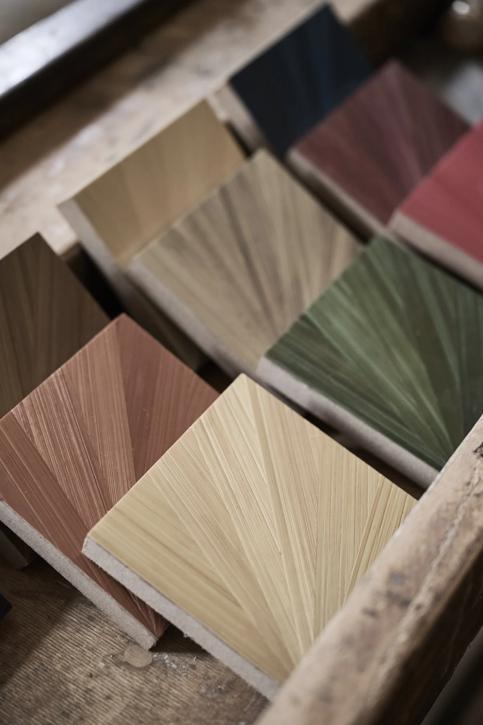 Close-up of straw color samples arranged on a table, showcasing various shades from beige to brown, green, red, and dark blue.