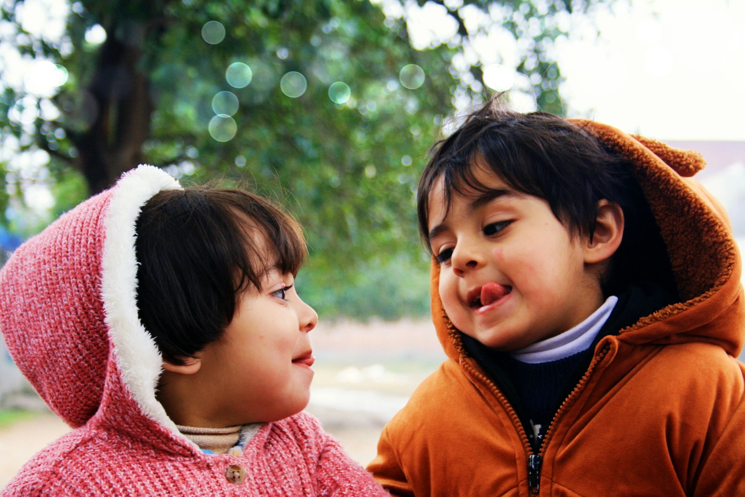 Two children making funny faces for each other.