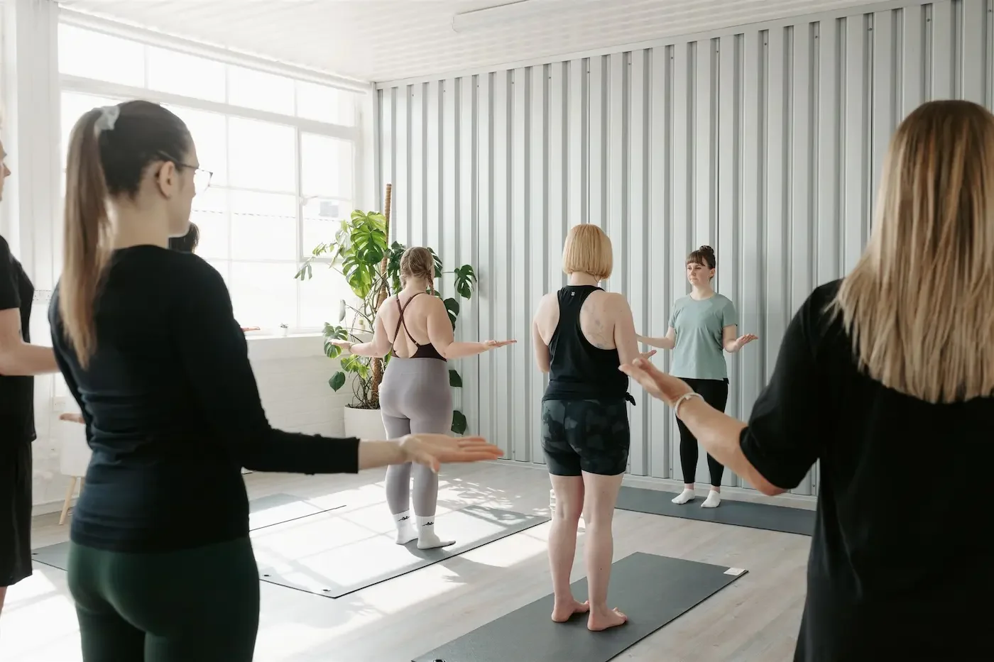 Group of Pilates beginners practicing shoulder mobility exercises at Meridian Yoga & Pilates in Glasgow’s East End