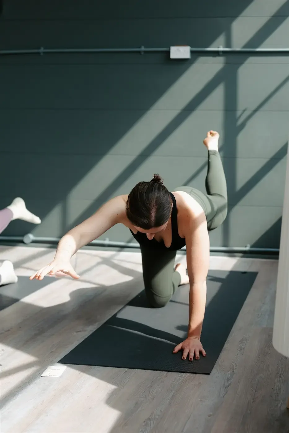  Person practicing balancing cat pose during a Core Yoga class at Meridian Yoga & Pilates in Glasgow’s East End