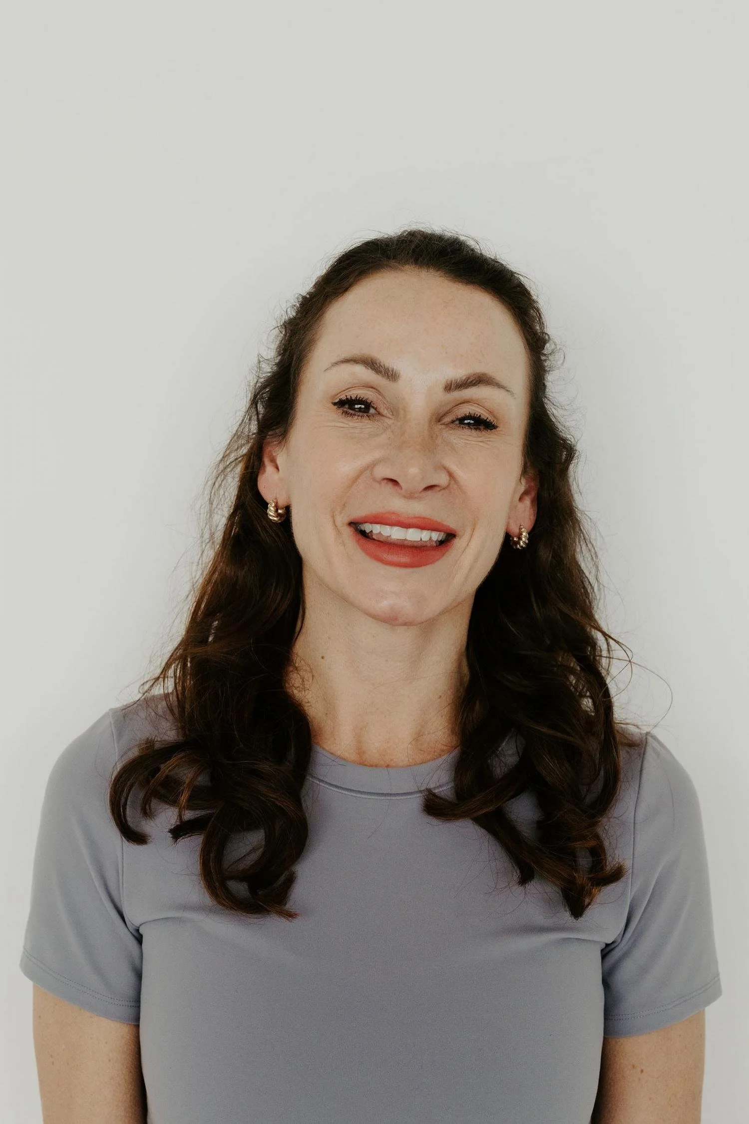 Portrait of Lorraine Livingstone, yoga teacher at Meridian Yoga & Pilates, smiling in the studio