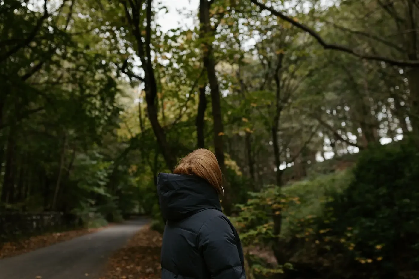 Michelle Lang, Shamanic Practitioner, pausing to admire trees during a mindfulness walk in a serene forest near Glasgow.