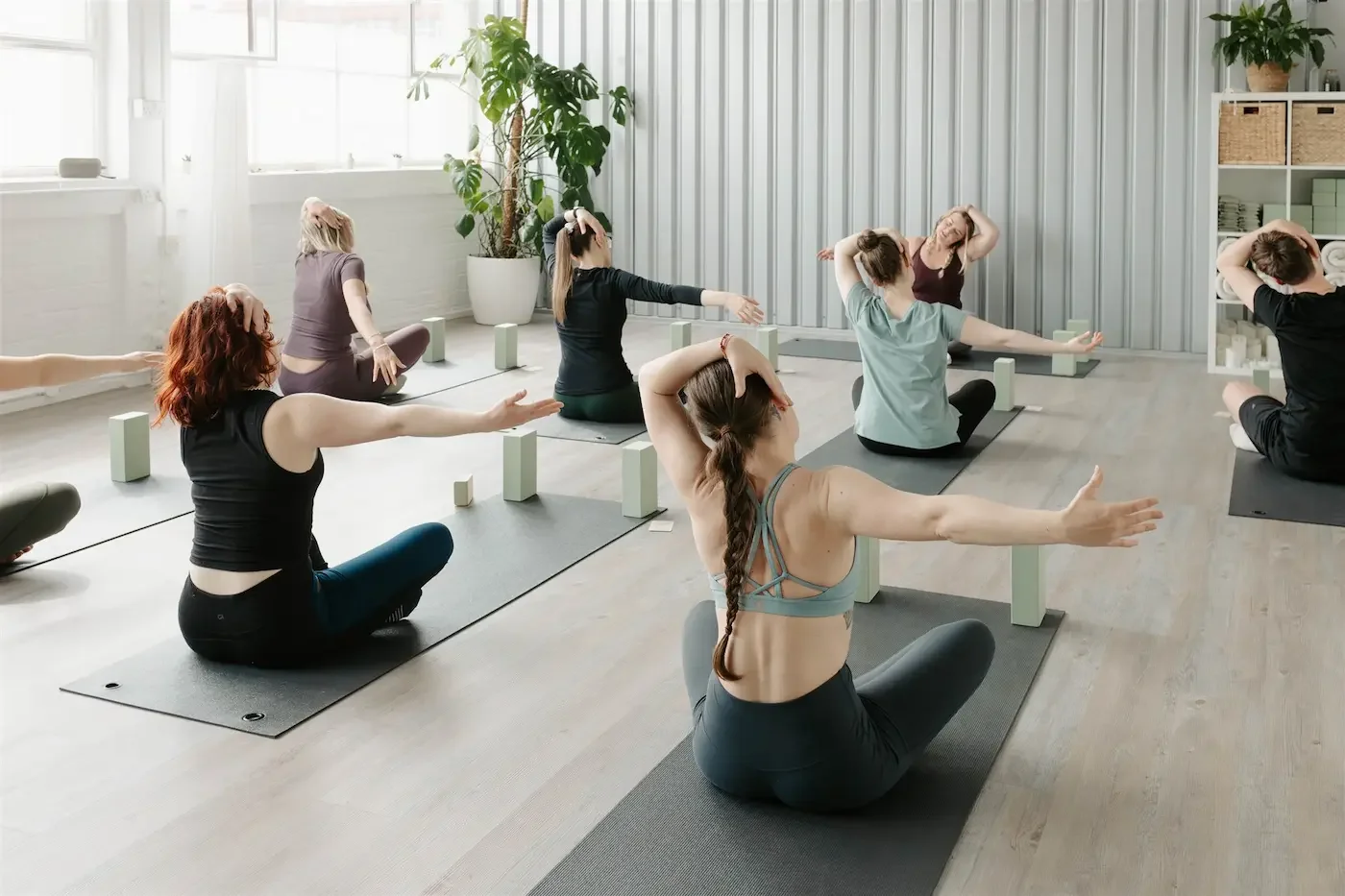 Group doing gentle seated neck stretches during an Astrology Yoga class at Meridian Yoga & Pilates in Glasgow’s East End
