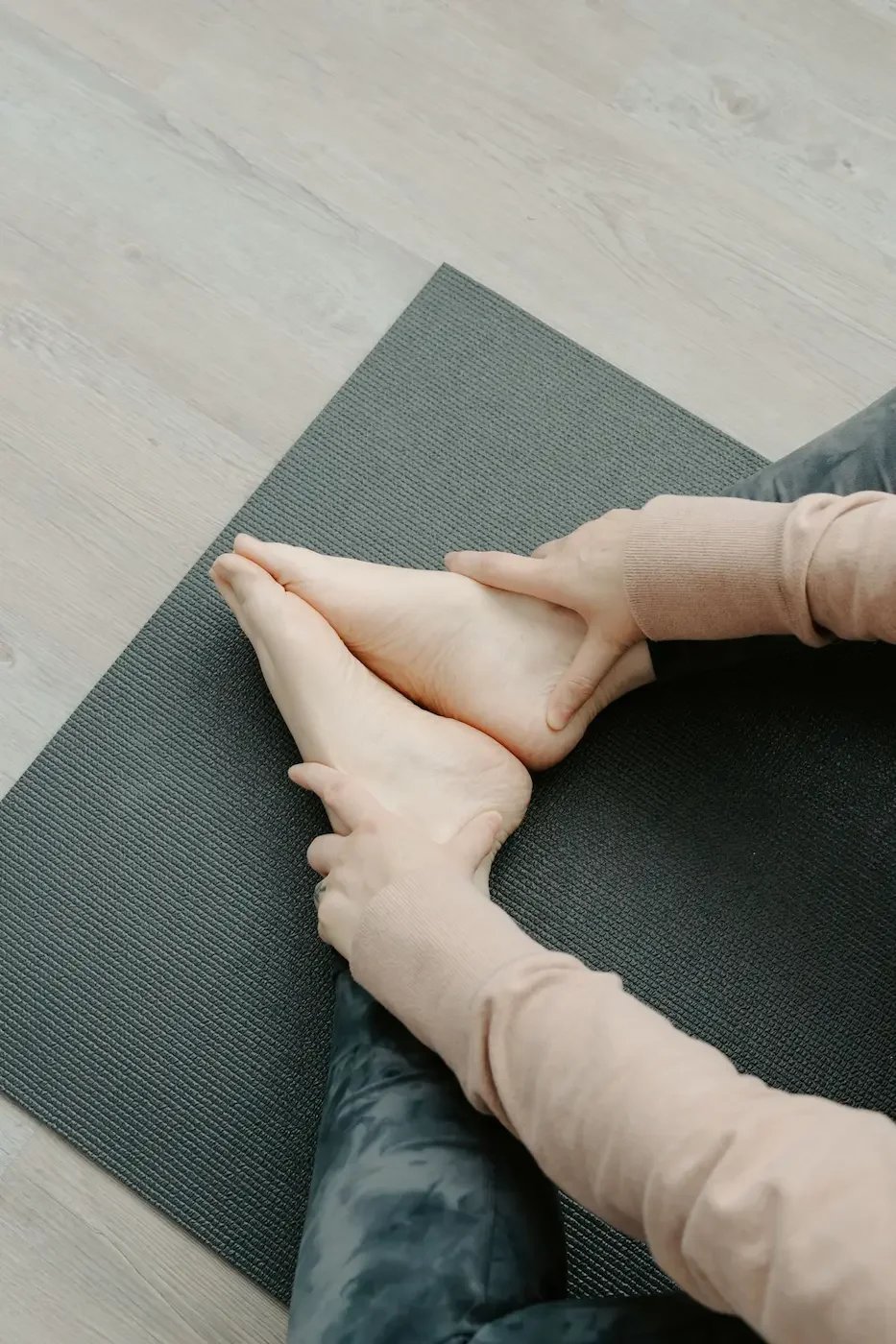 Feet pressed together in a butterfly pose on a yoga mat at Meridian Yoga and Pilates in Dennistoun.