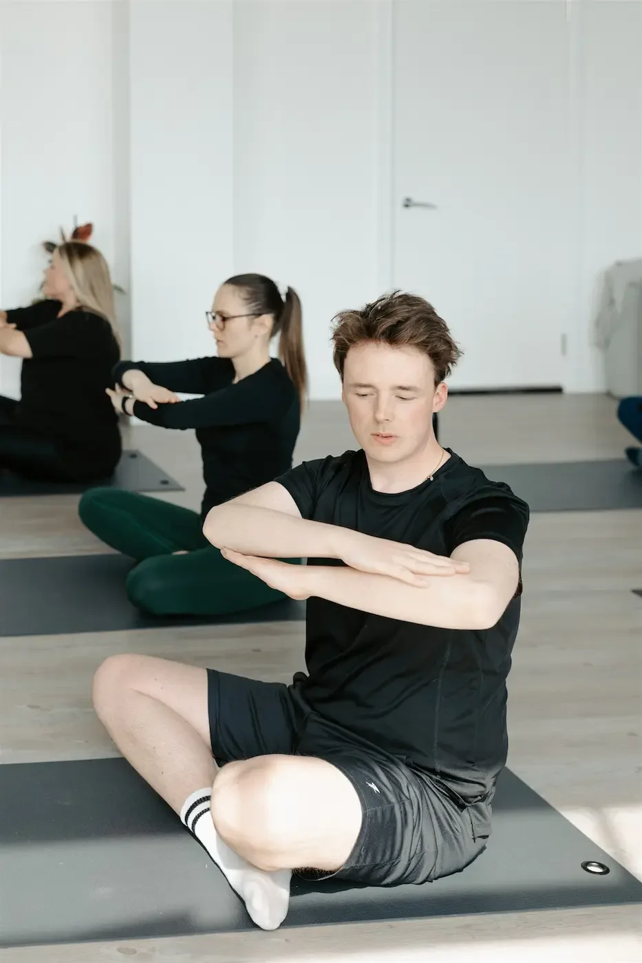 People practicing gentle twists during the Thursday Reset Pilates class at Meridian Yoga & Pilates in Glasgow’s East End