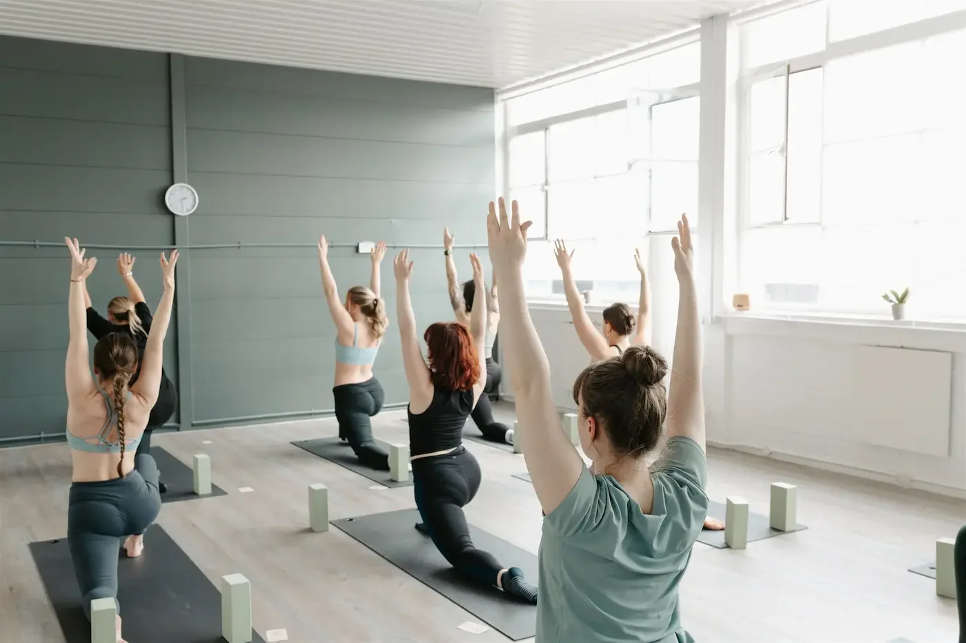 Group practicing low lunge during a Vinyasa Flow class at Meridian Yoga & Pilates in Glasgow’s East End