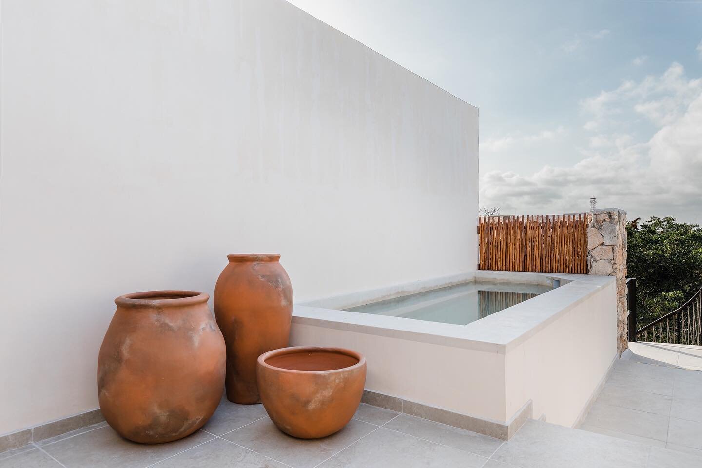 Large terracotta pots and a simple wooden fence add a pop of color, texture and some extra depth &amp; dimension to this poolside area 💧

From our Watal project.