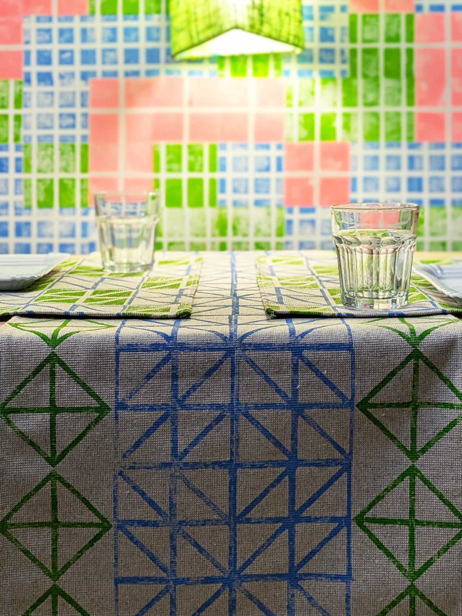 cosy contemporary studio scene with set table with place mats and table runner in geometric triangular patterns