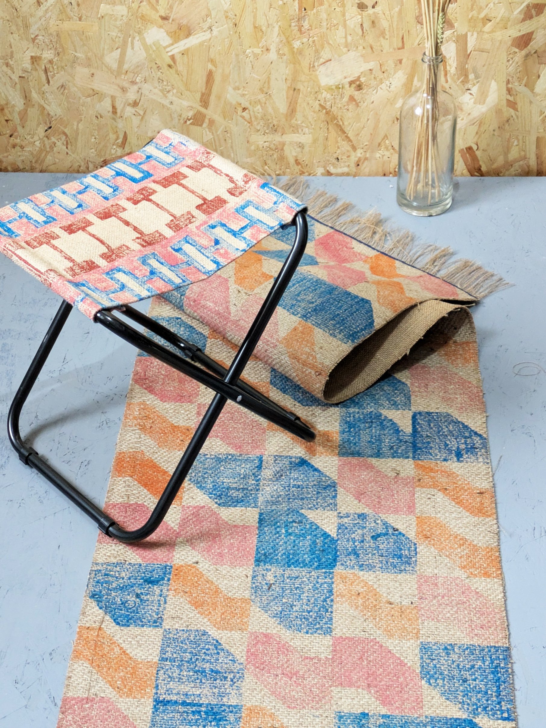 studio scene with chair and runner rug in bold contemporary colour combinations of soft pastel pink and orange