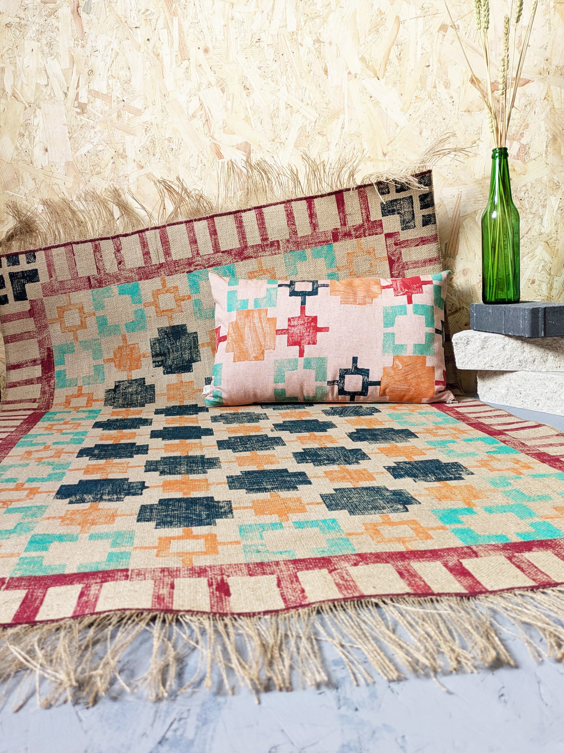 bold interior decor with geometric pattern on rug and cushion in warm colours