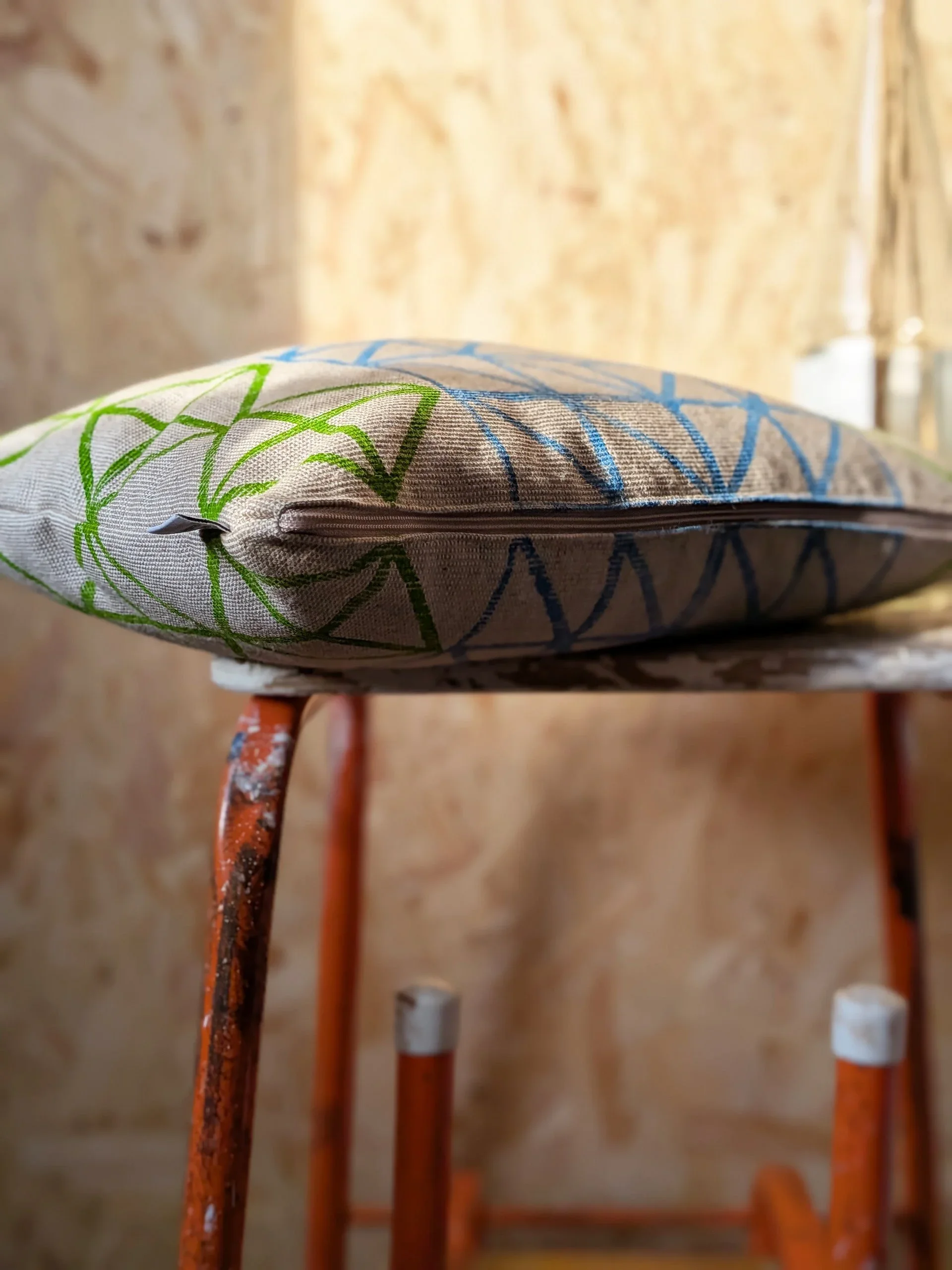 contemporary interior scene with colourful print on cushion on stool