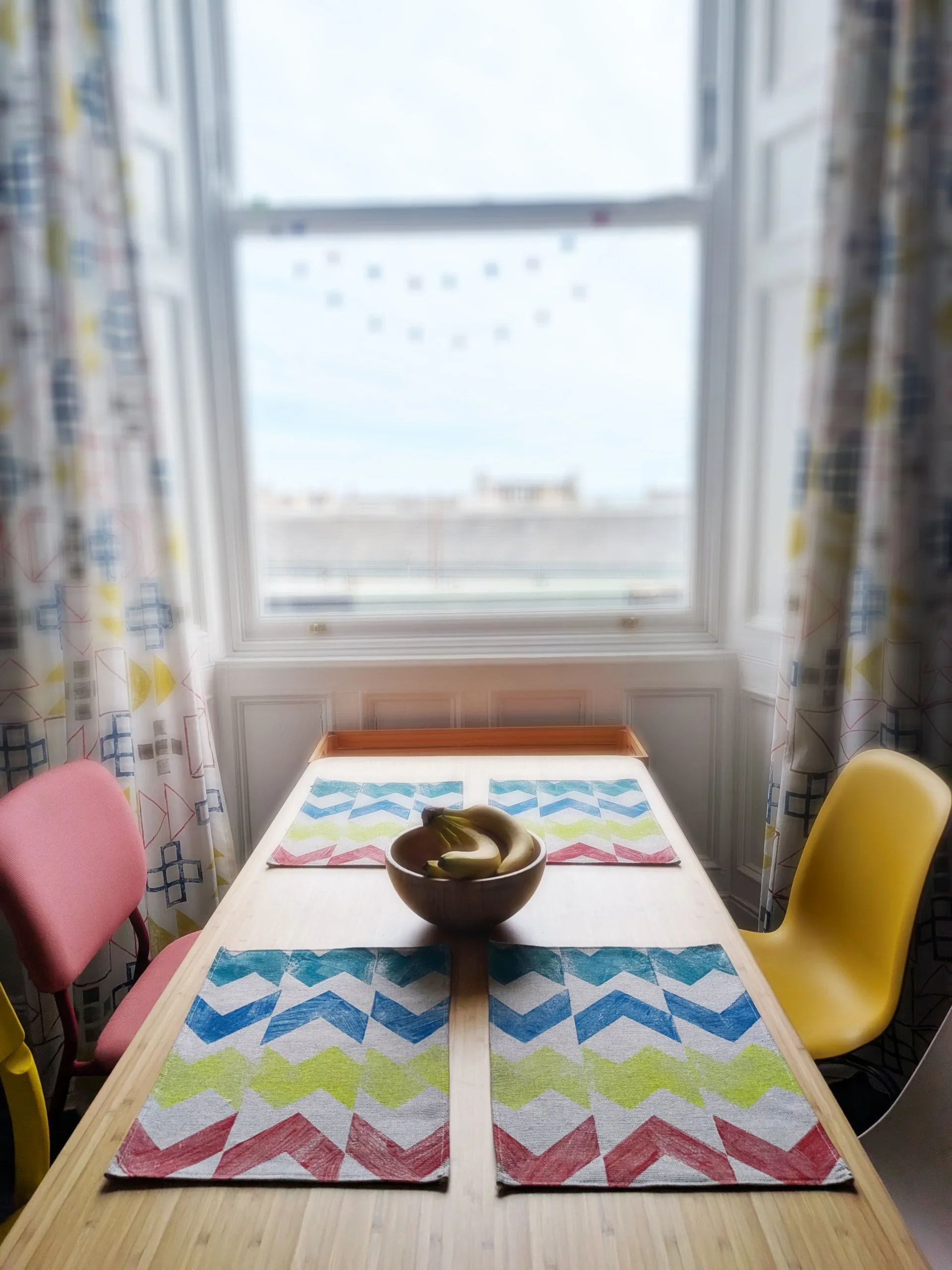 bright kitchen scene with colourful hand pinted geometric place mats on table