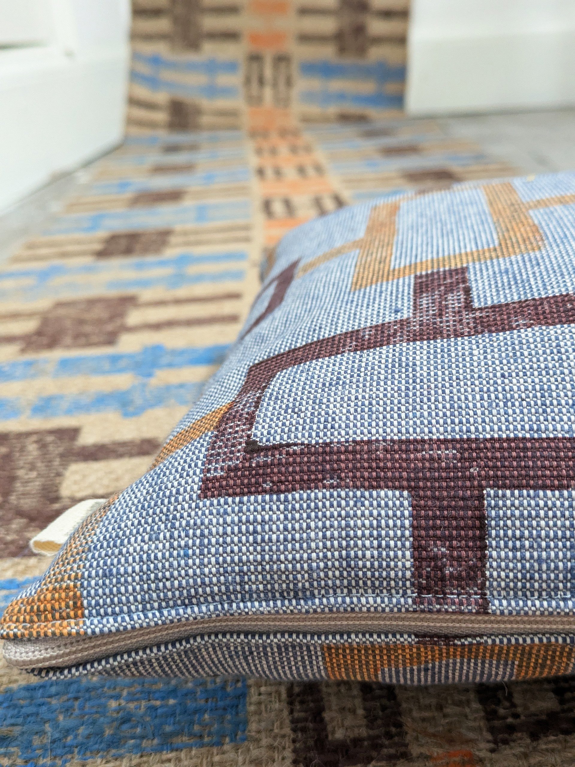 close-up detail of denim-like fabric on handmade cushion with simple block printed pattern