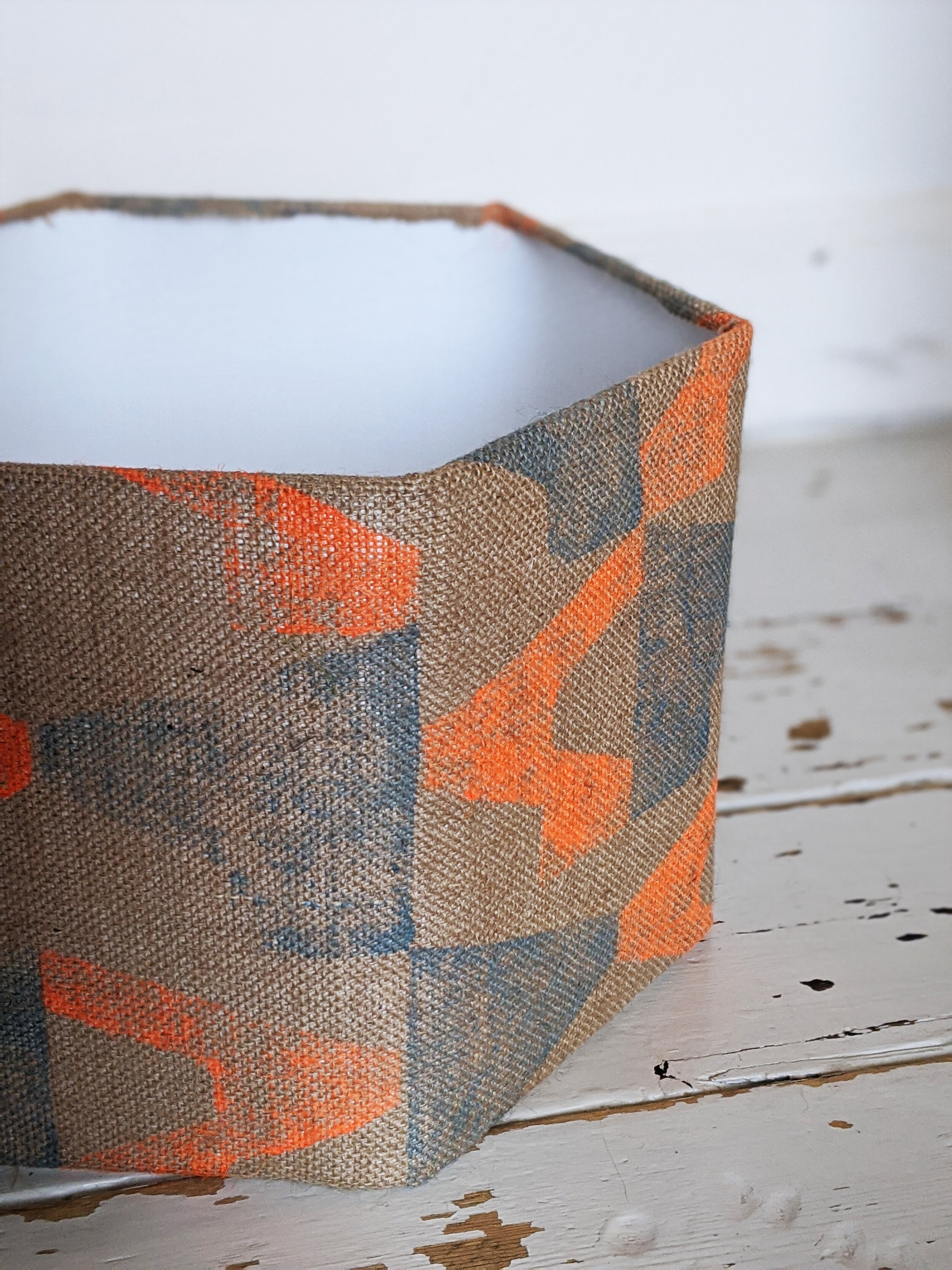 MÁVAUT hexagonal lampshade with orange and blue print design on jute