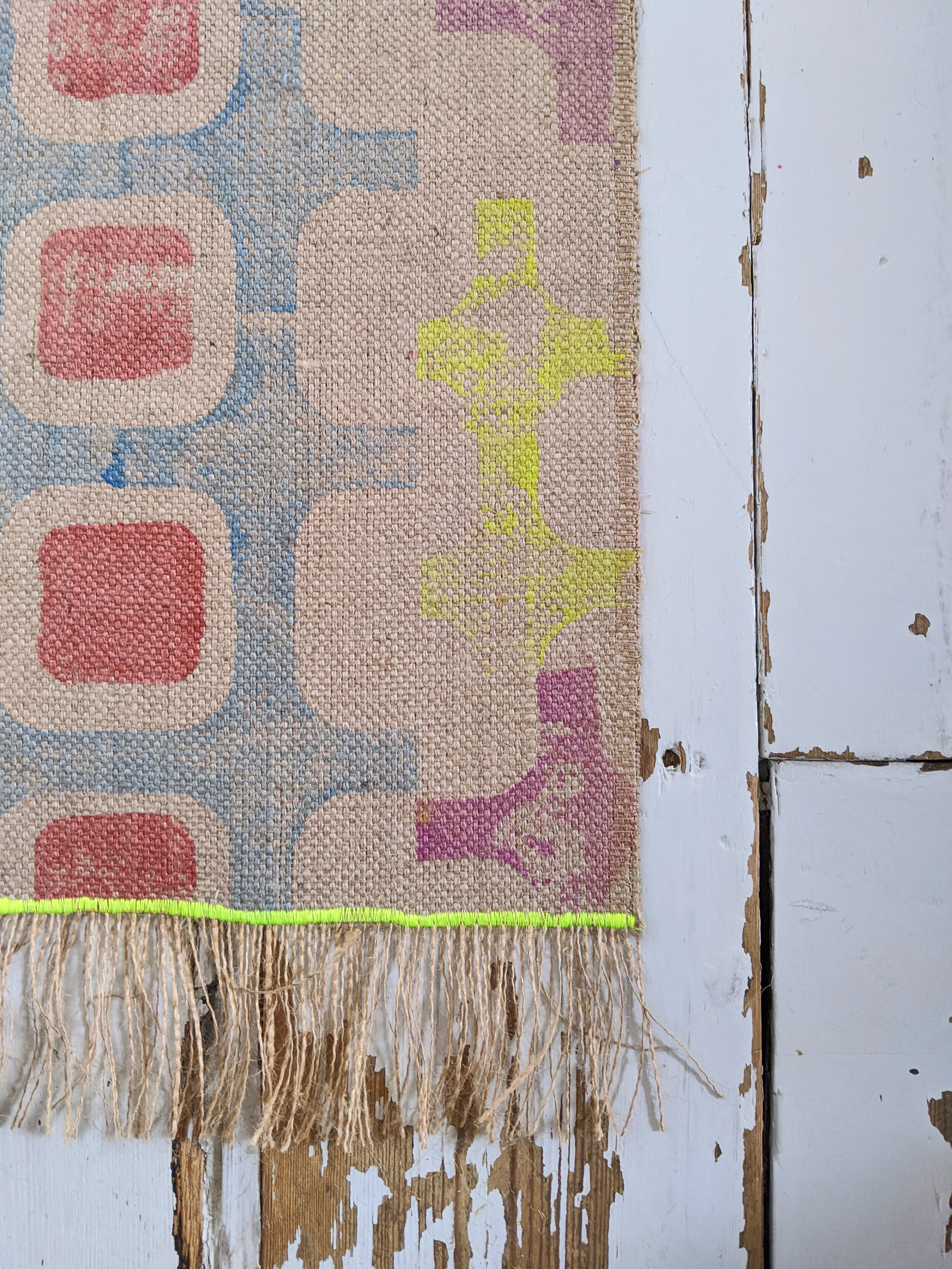 CO-OP runner rug with geometric blue and orange print and yellow stitch