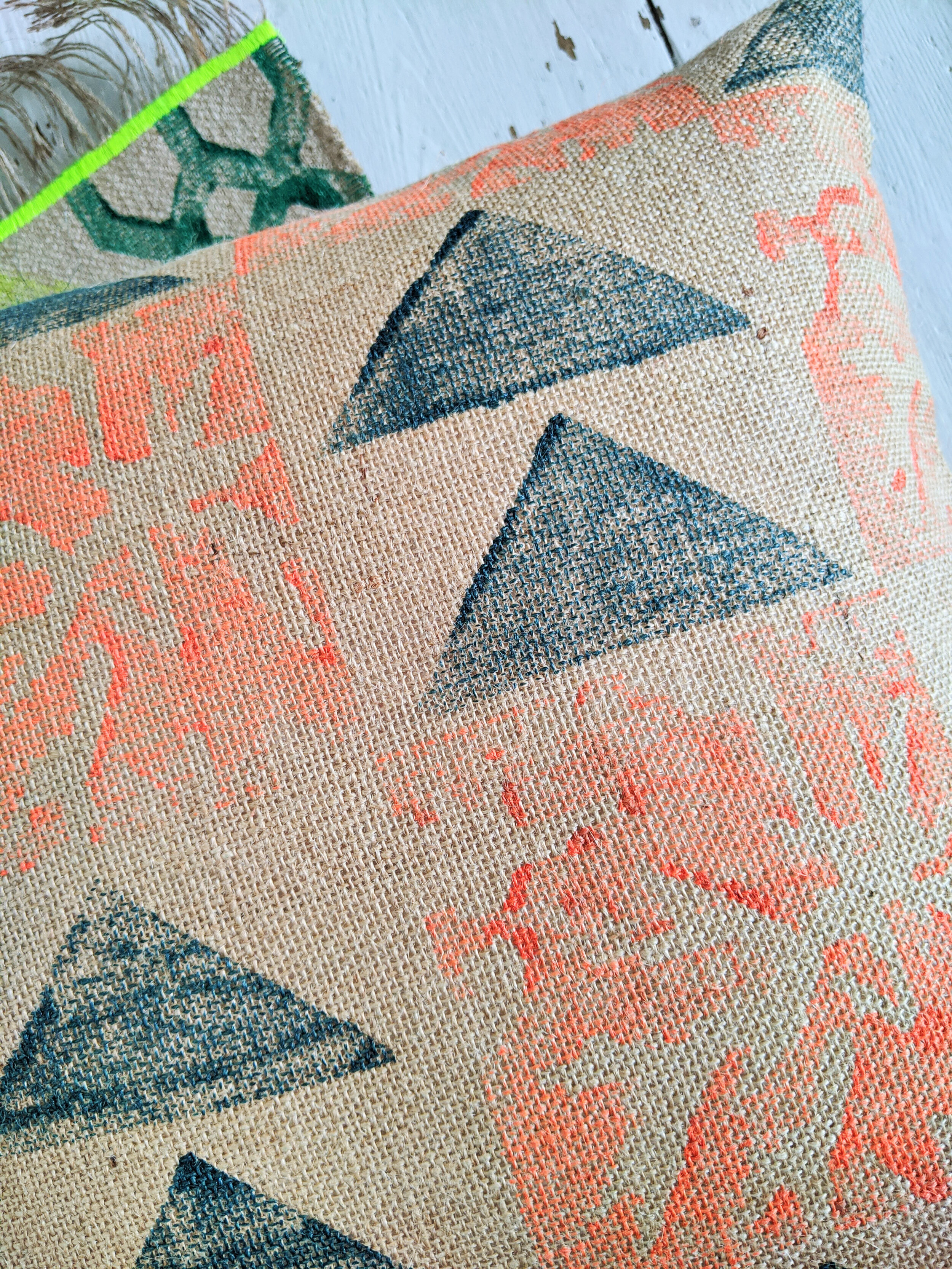 PÁLMAHÁZ neon orange and teal block print jute cushion close-up detail of palm leaf and triangle design