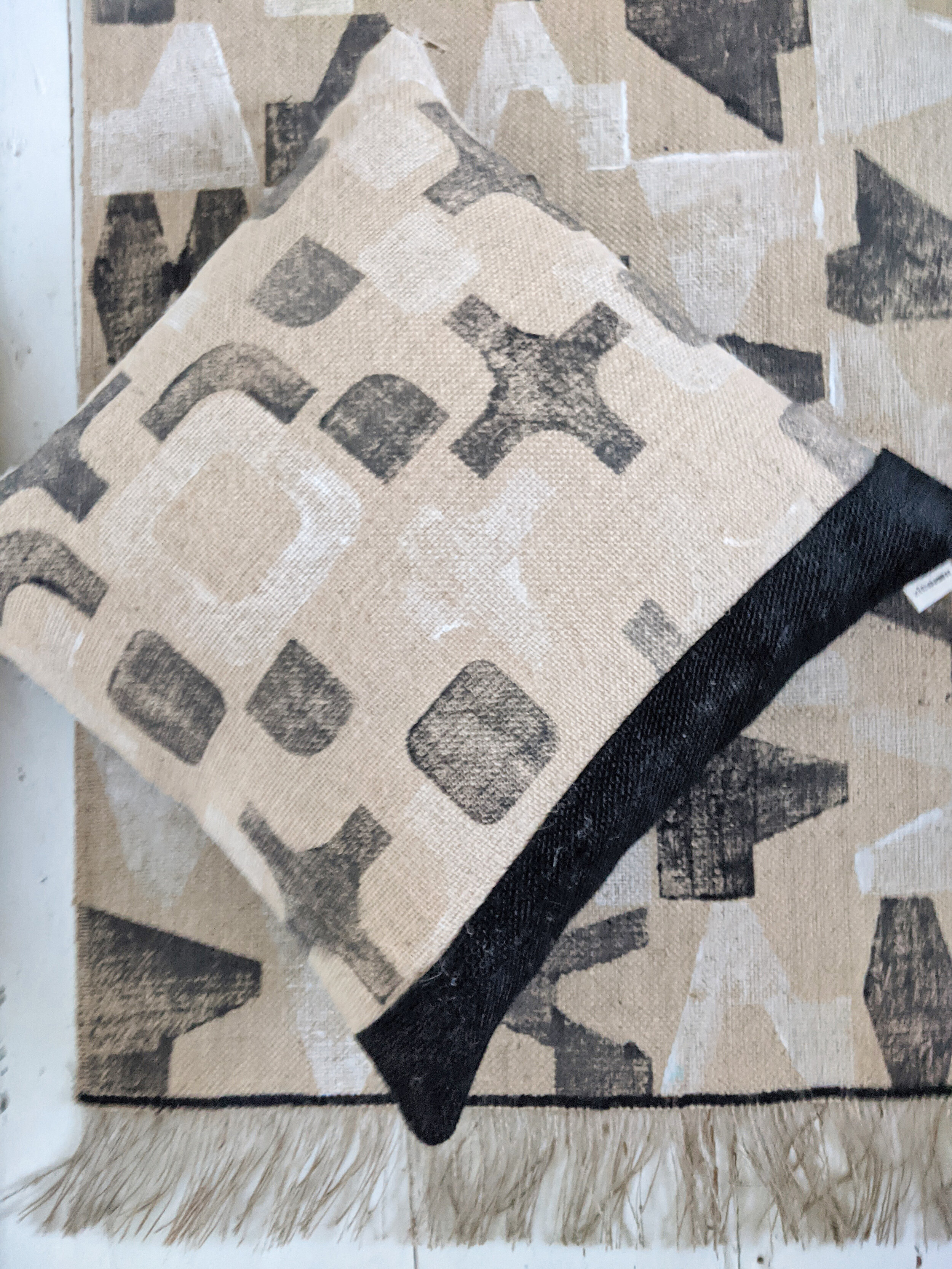 CO-OP black and white geometric random block print cushion on printed jute rug
