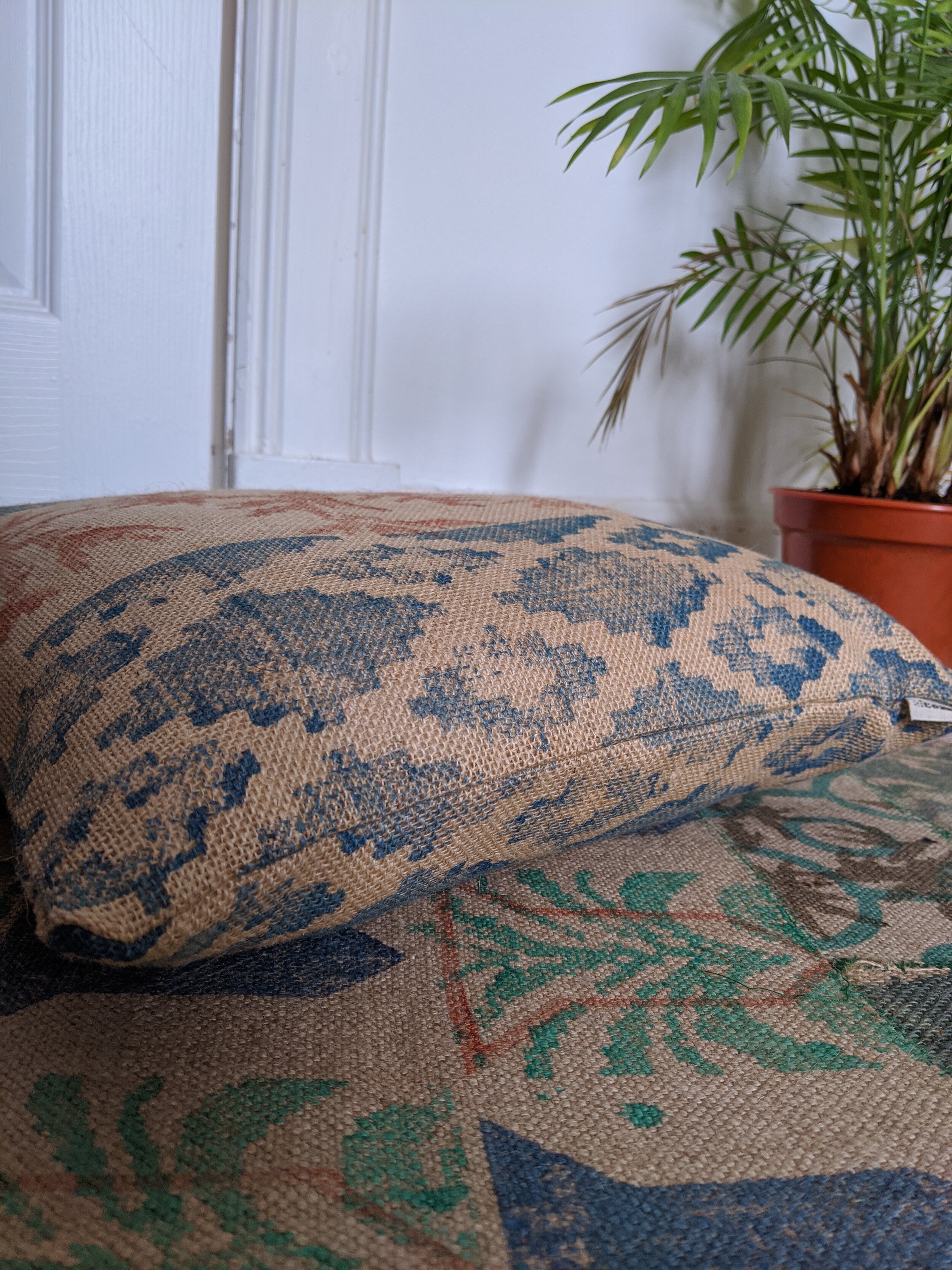NOMÁD block printed jute cushion with boho design on leaf print rug