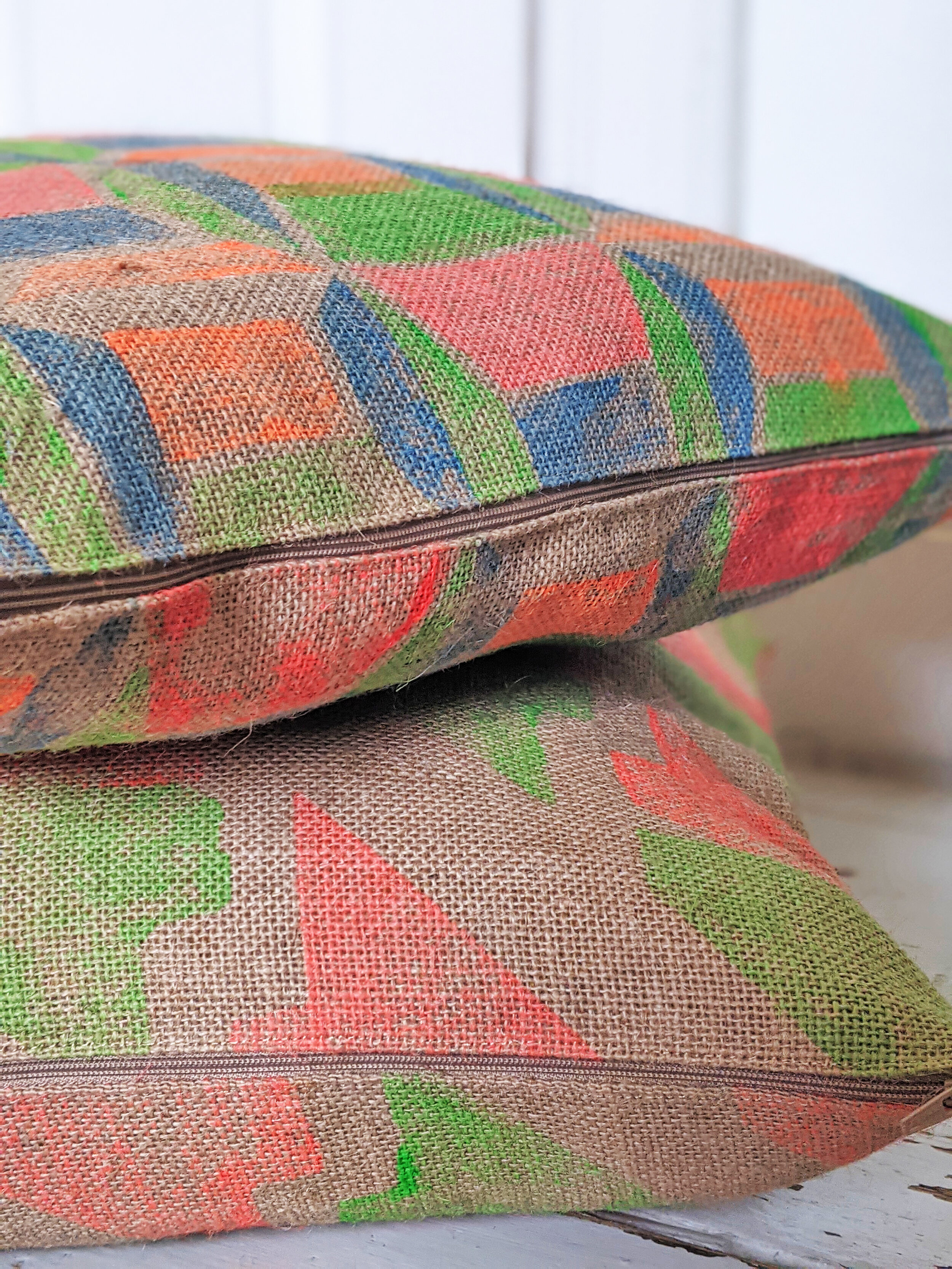 natural jute cushions in modernist designs placed on top of each-other, hand block printed with geometric designs